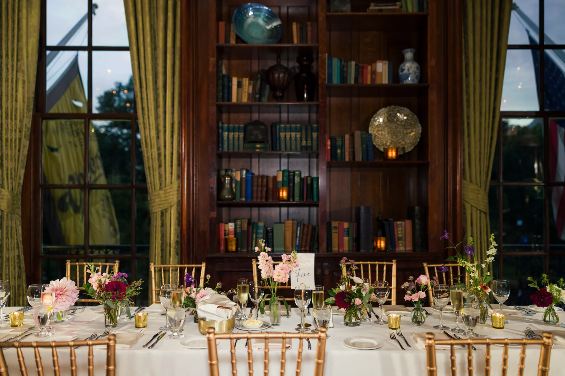 Elegant reception table with floral centerpieces and gold chiavari chairs at Hampshire House in Boston, MA.