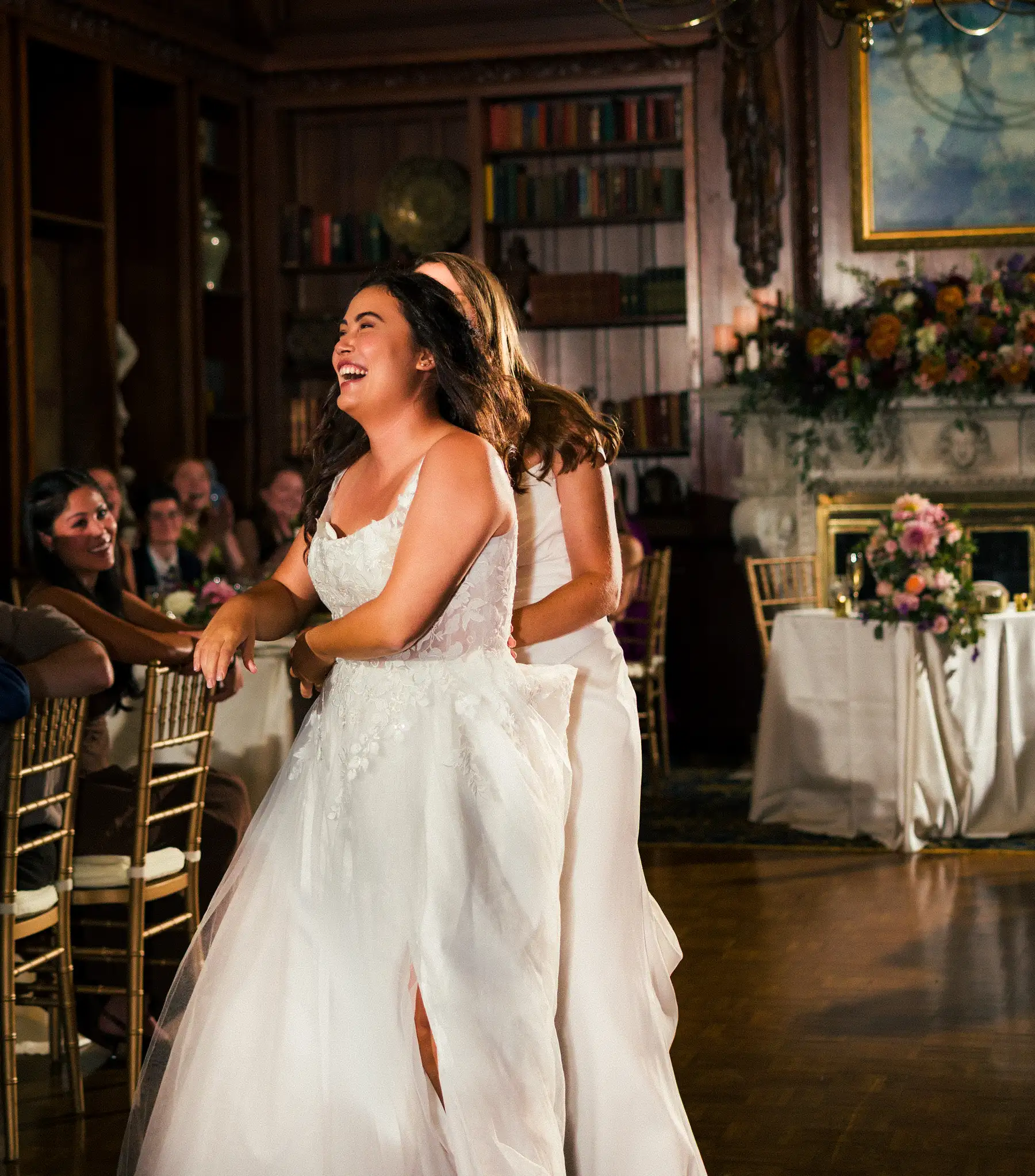 Bride Ashton Hattori laughs joyfully while dancing with bride Stephanie Tillman at their Hampshire House wedding reception in Boston.