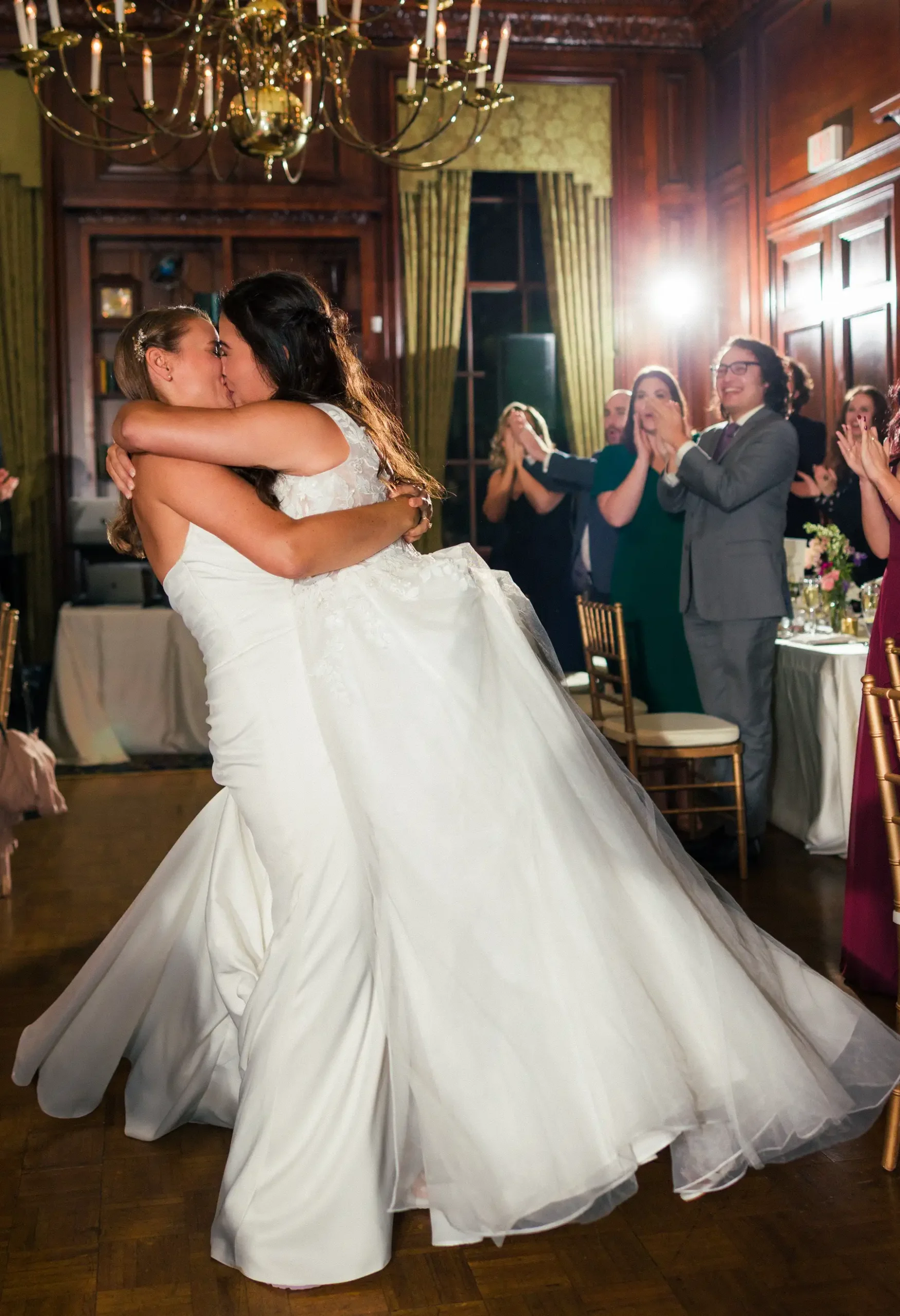 Brides Ashton Hattori and Stephanie Tillman share a first dance kiss at Hampshire House in Boston as guests applaud.