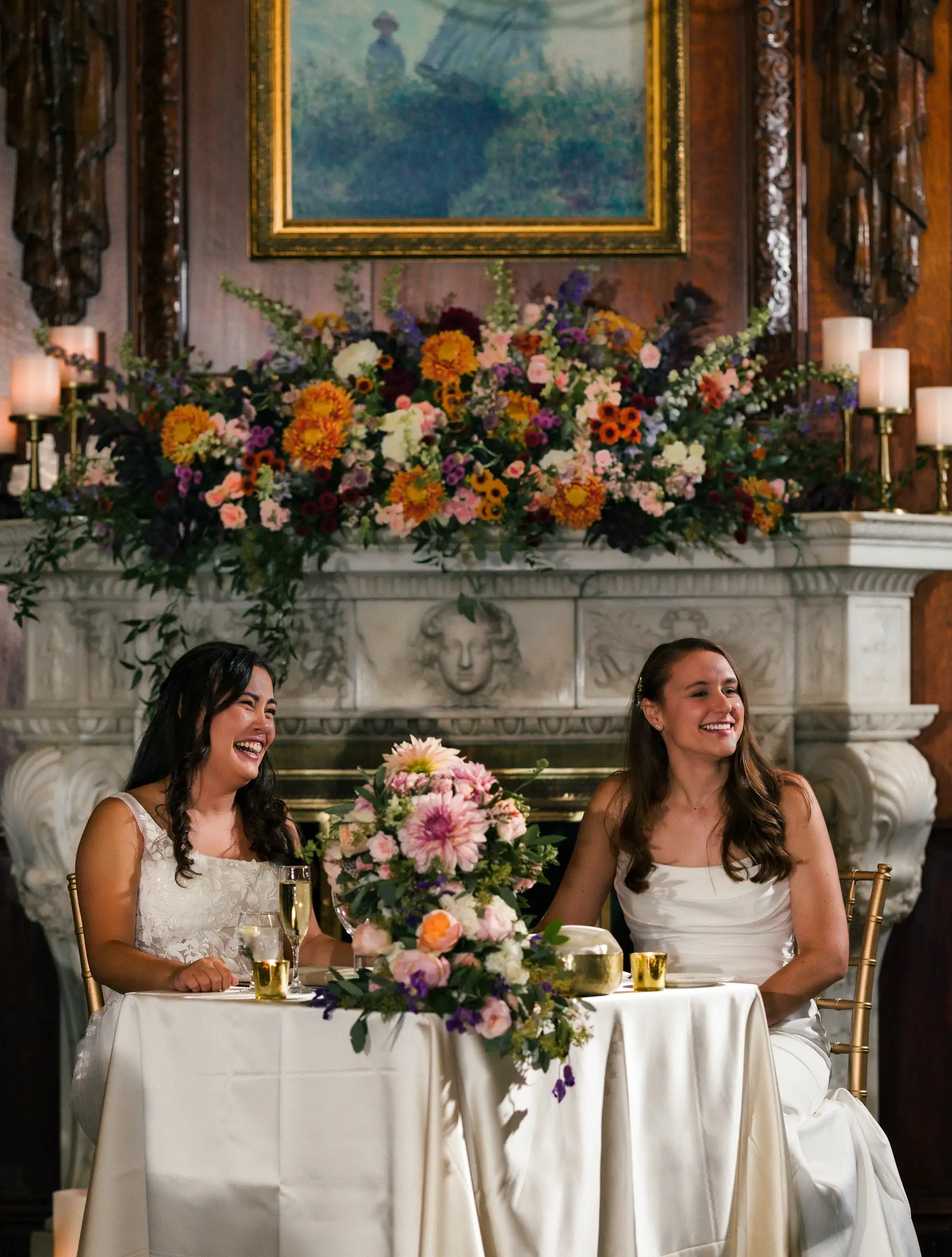 Brides Ashton Hattori and Stephanie Tillman laugh at their sweetheart table at Hampshire House in Boston.