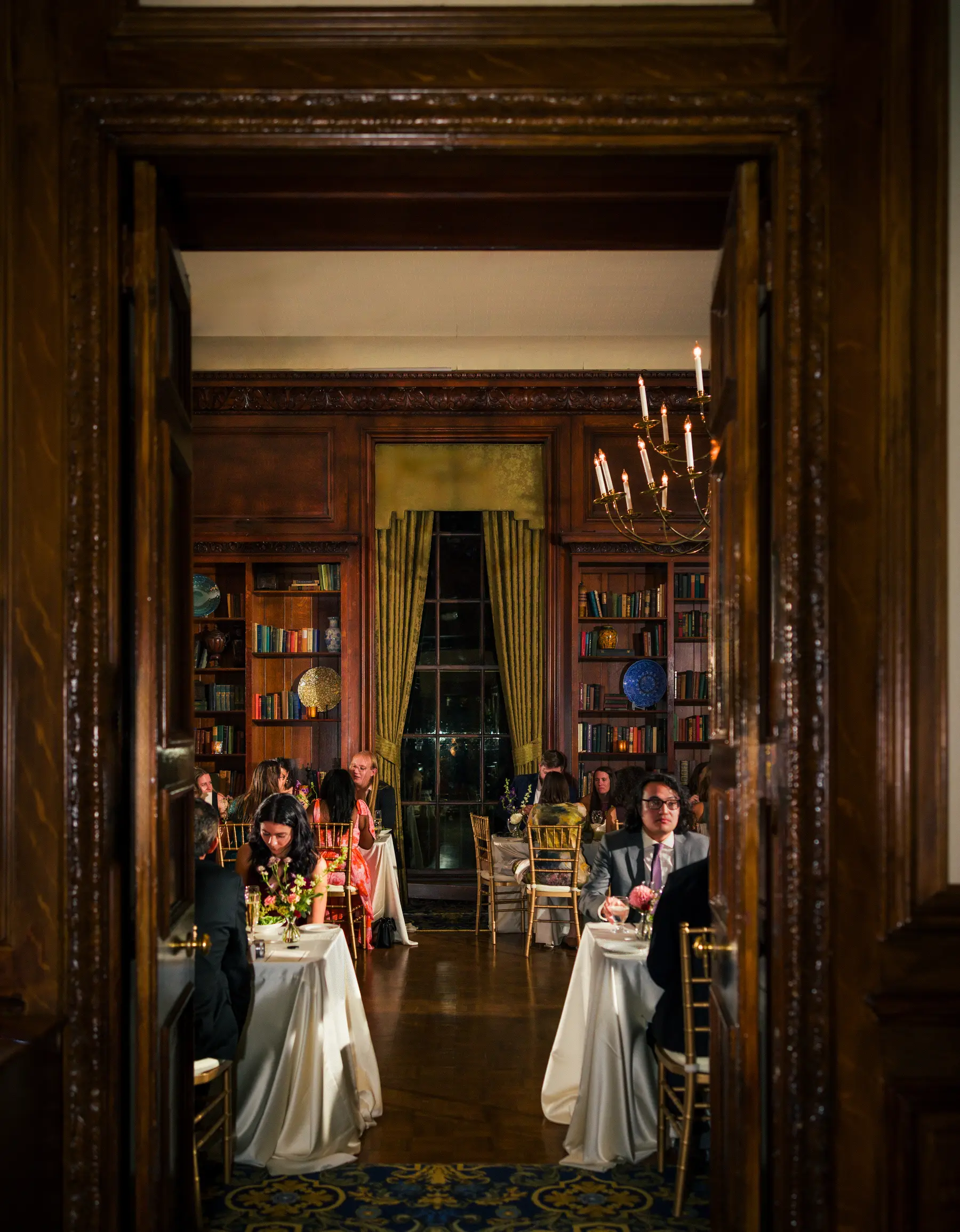 Guests dine in the candlelit library at Hampshire House in Boston during Ashton Hattori and Stephanie Tillman's wedding reception.