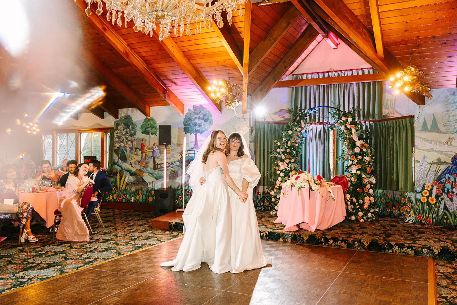 Brides Mimi and Courtney hold hands and smile on the dance floor at Madonna Inn in San Luis Obispo, California.
