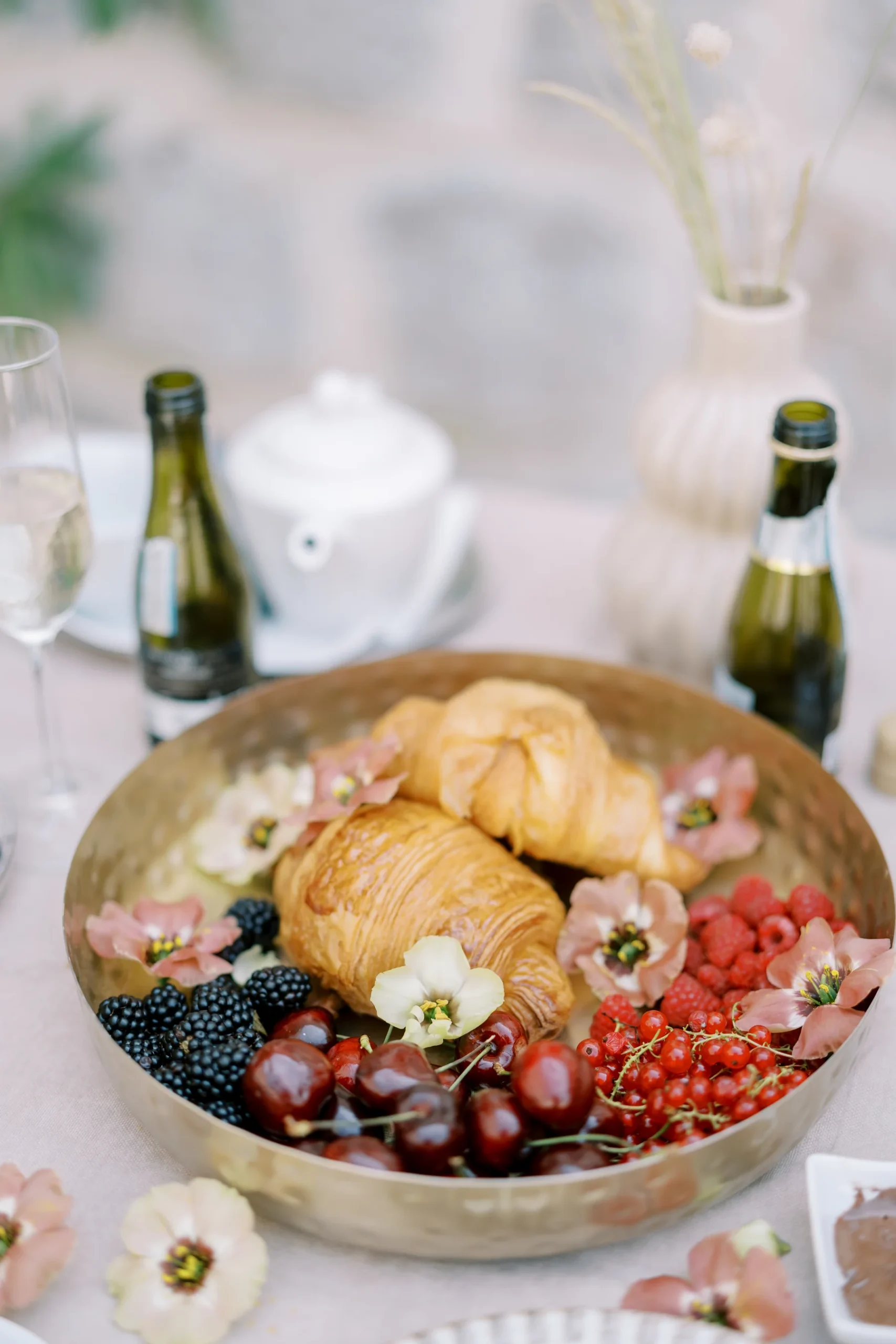 A gold tray of croissants, cherries, blackberries, raspberries and edible flowers at Monte Bay Retreat in Perast, Montenegro.