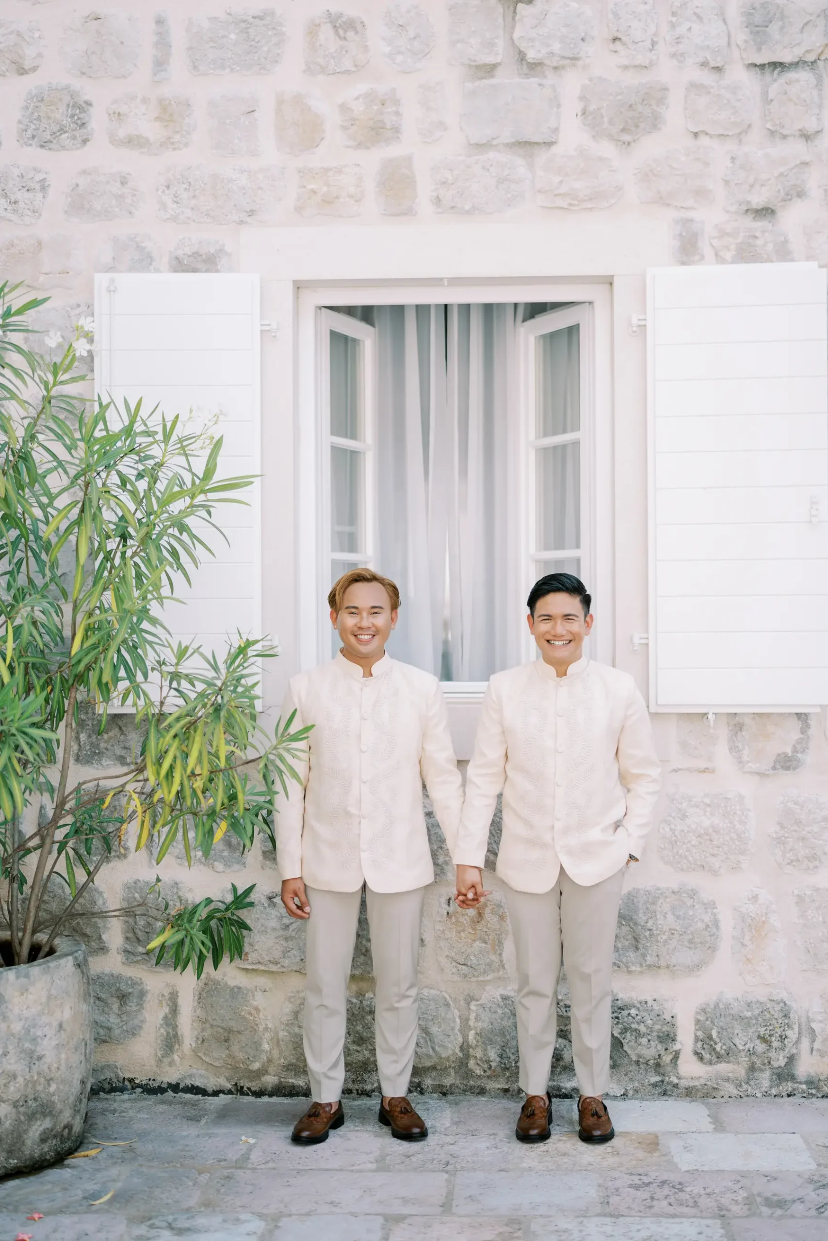 Ryan Jake Pisueña and Jori Blas Lazalita hold hands in matching ivory barong outfits at Monte Bay Retreat in Perast, Montenegro.