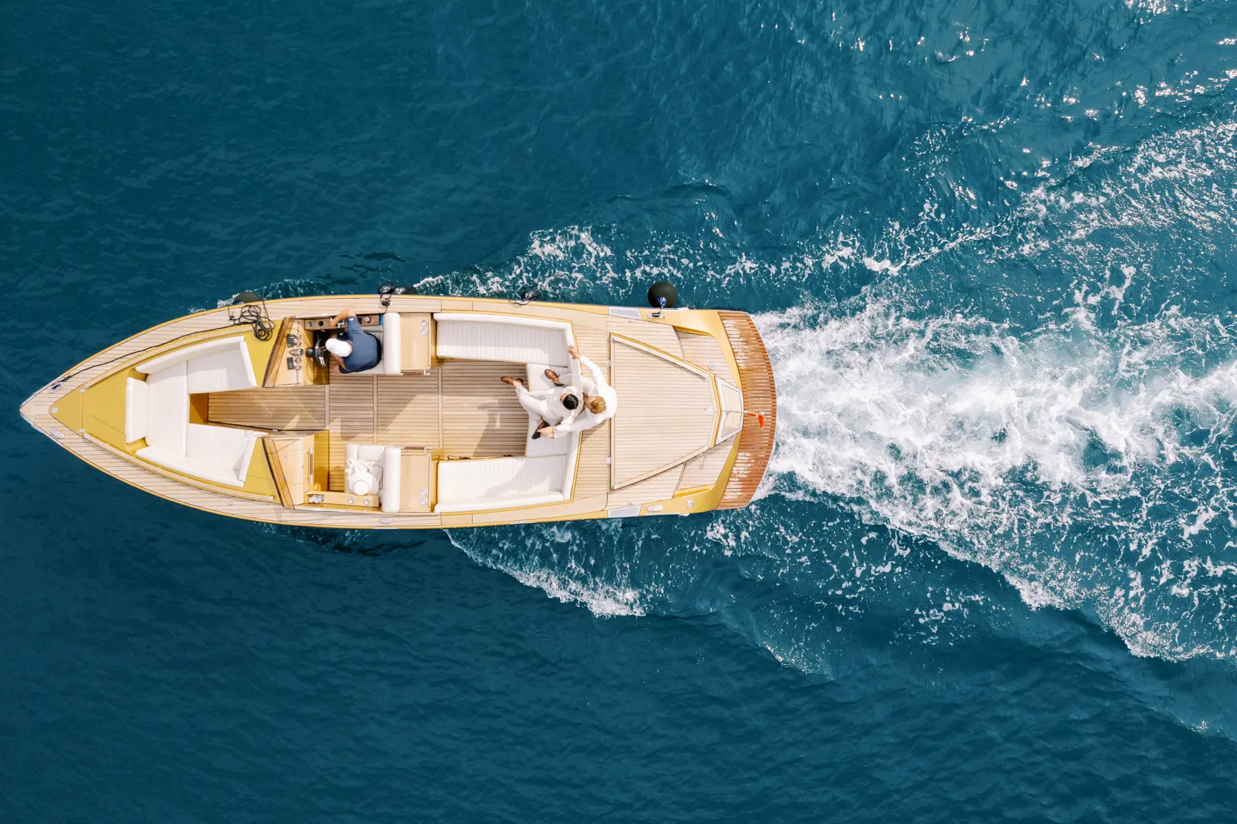 Ryan and Jori ride a sleek yellow motorboat across turquoise Adriatic waters near Perast, Montenegro.