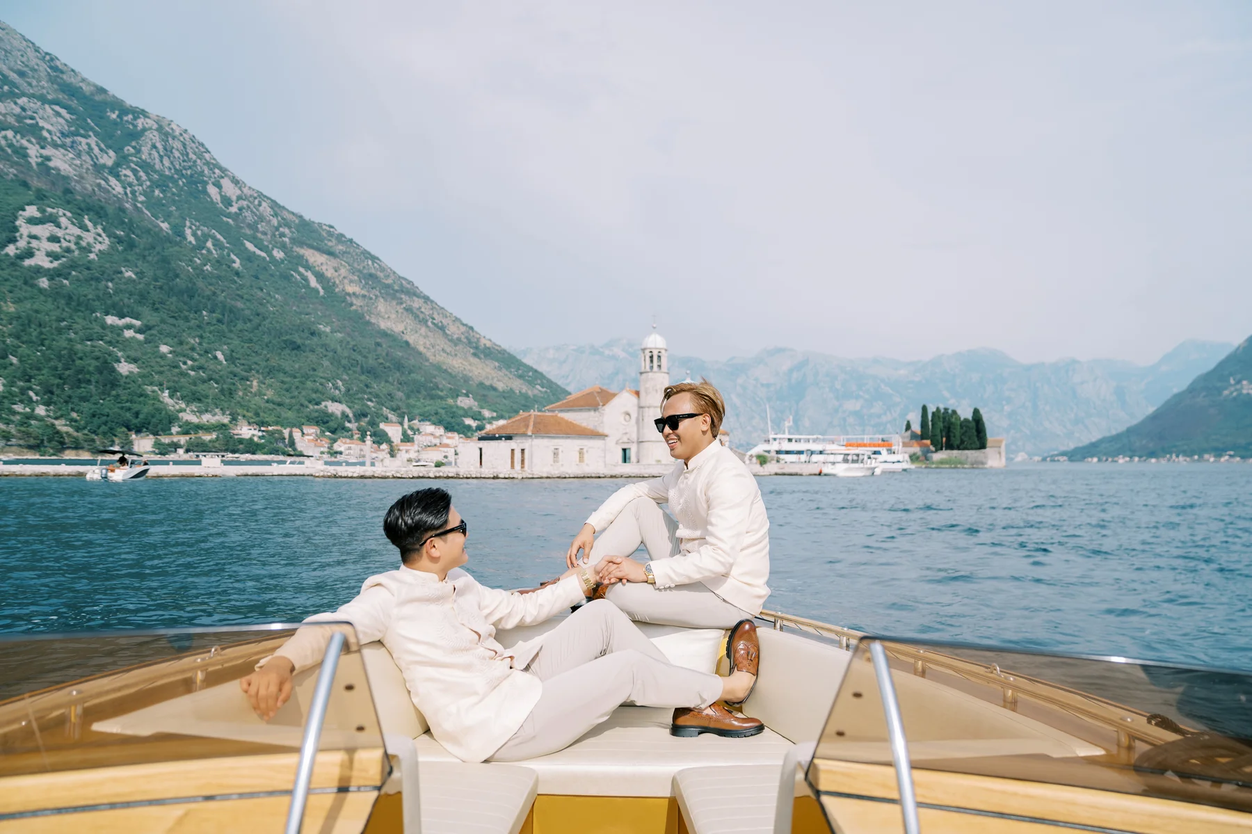 Ryan Jake Pisueña and Jori Blas Lazalita hold hands on a luxury boat in the Bay of Kotor, Montenegro.