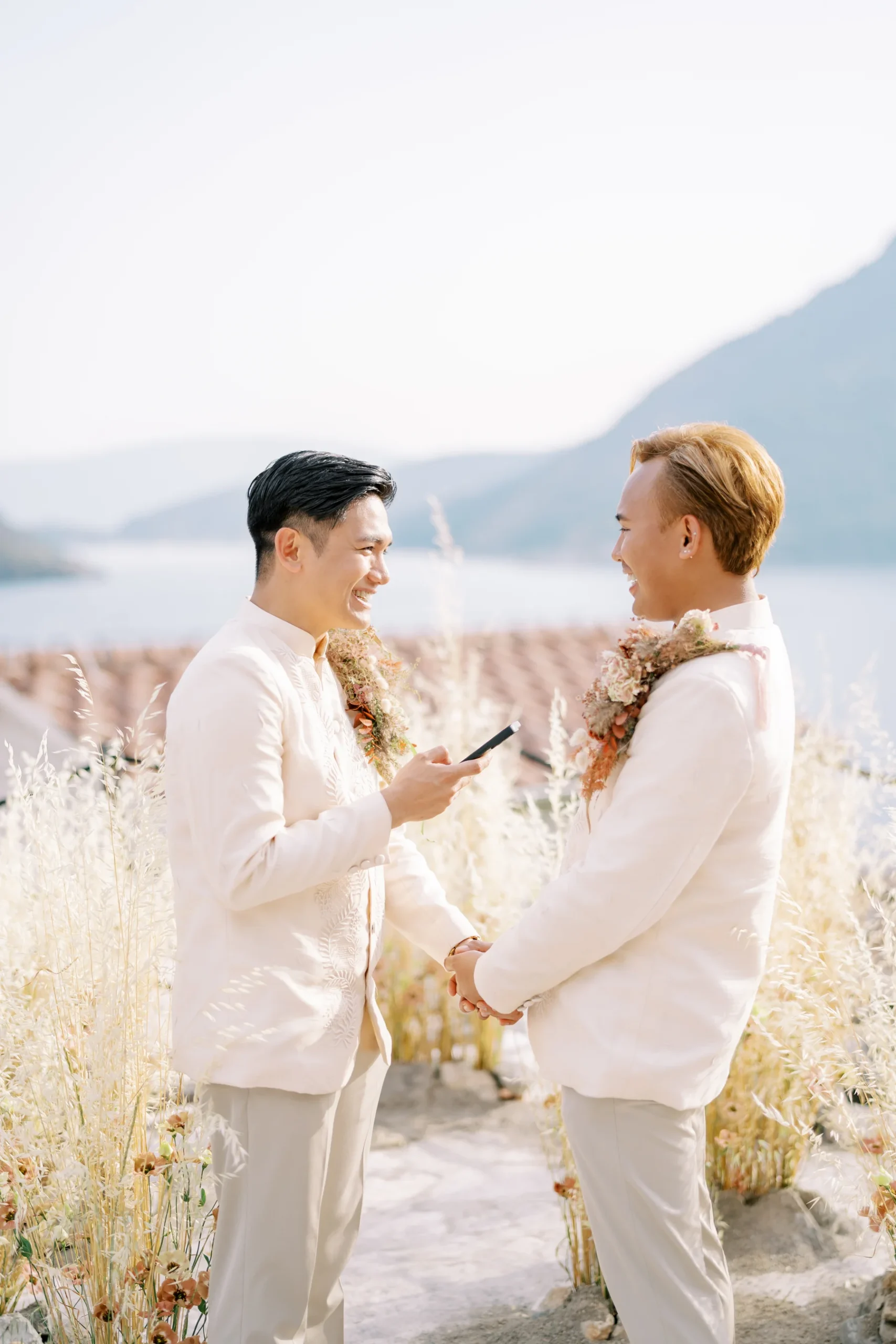Ryan Jake and Jori smile and hold hands during outdoor vow exchange at Monte Bay Retreat in Perast, Montenegro.