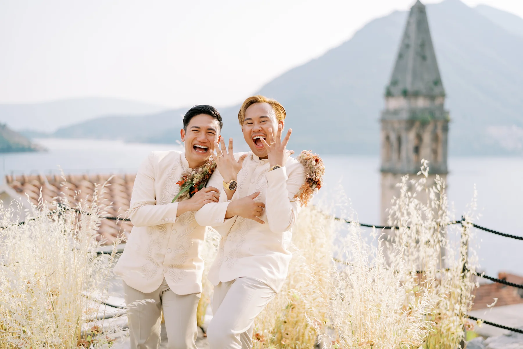 Ryan Jake Pisueña and Jori Blas Lazalita laugh joyfully while showing their wedding rings at Monte Bay Retreat in Perast, Montenegro.