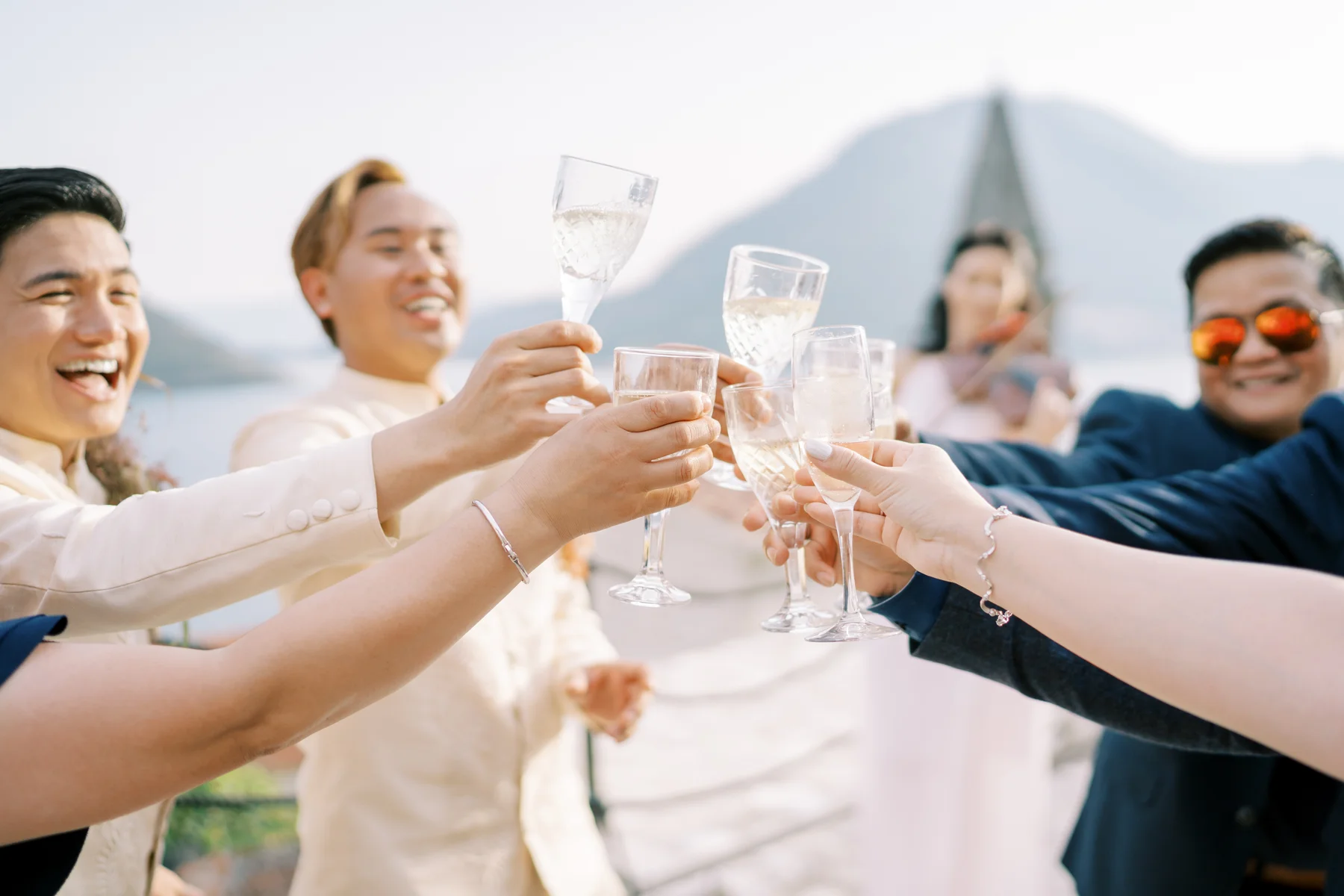 Guests raise champagne glasses in a joyful toast at Ryan Jake and Jori's wedding at Monte Bay Retreat in Perast, Montenegro.