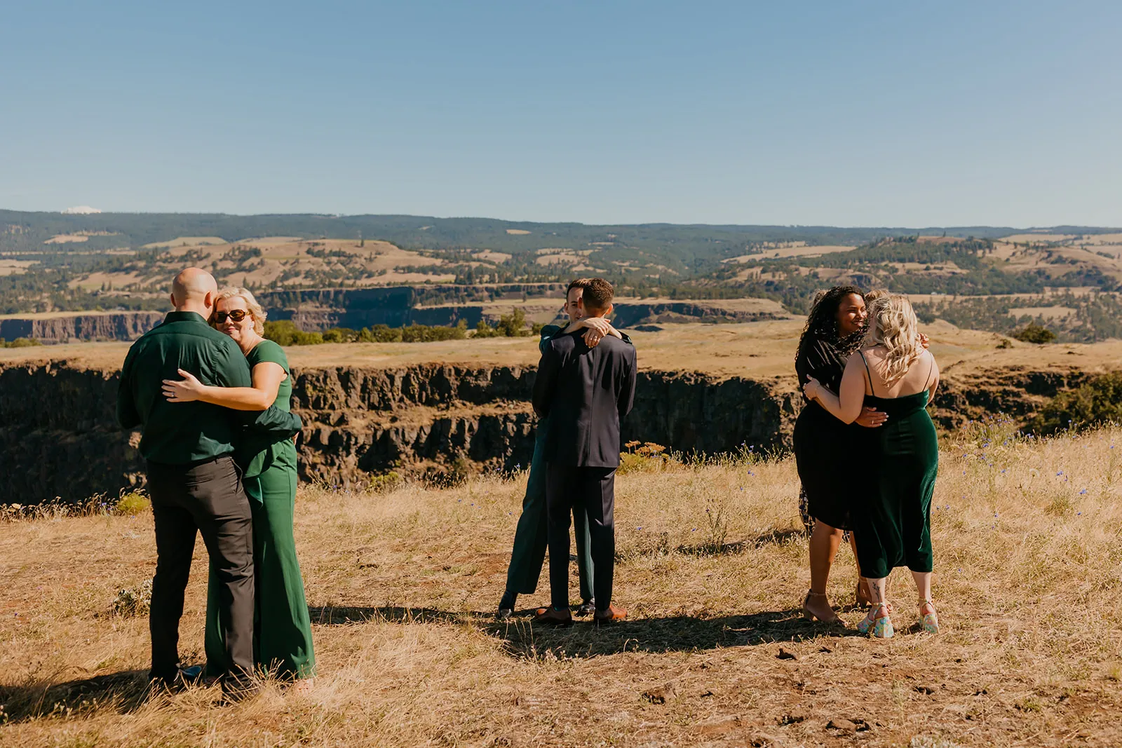 Guests hug and celebrate with Ben and Nolan after their wedding ceremony at Mayer State Park in Mosier, OR.