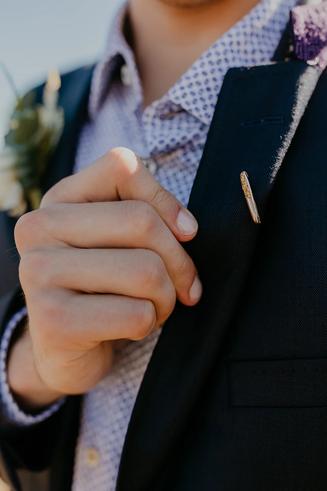 A close-up of a lapel pin on the dark navy suit jacket worn by groom at Mayer State Park in Mosier, OR.