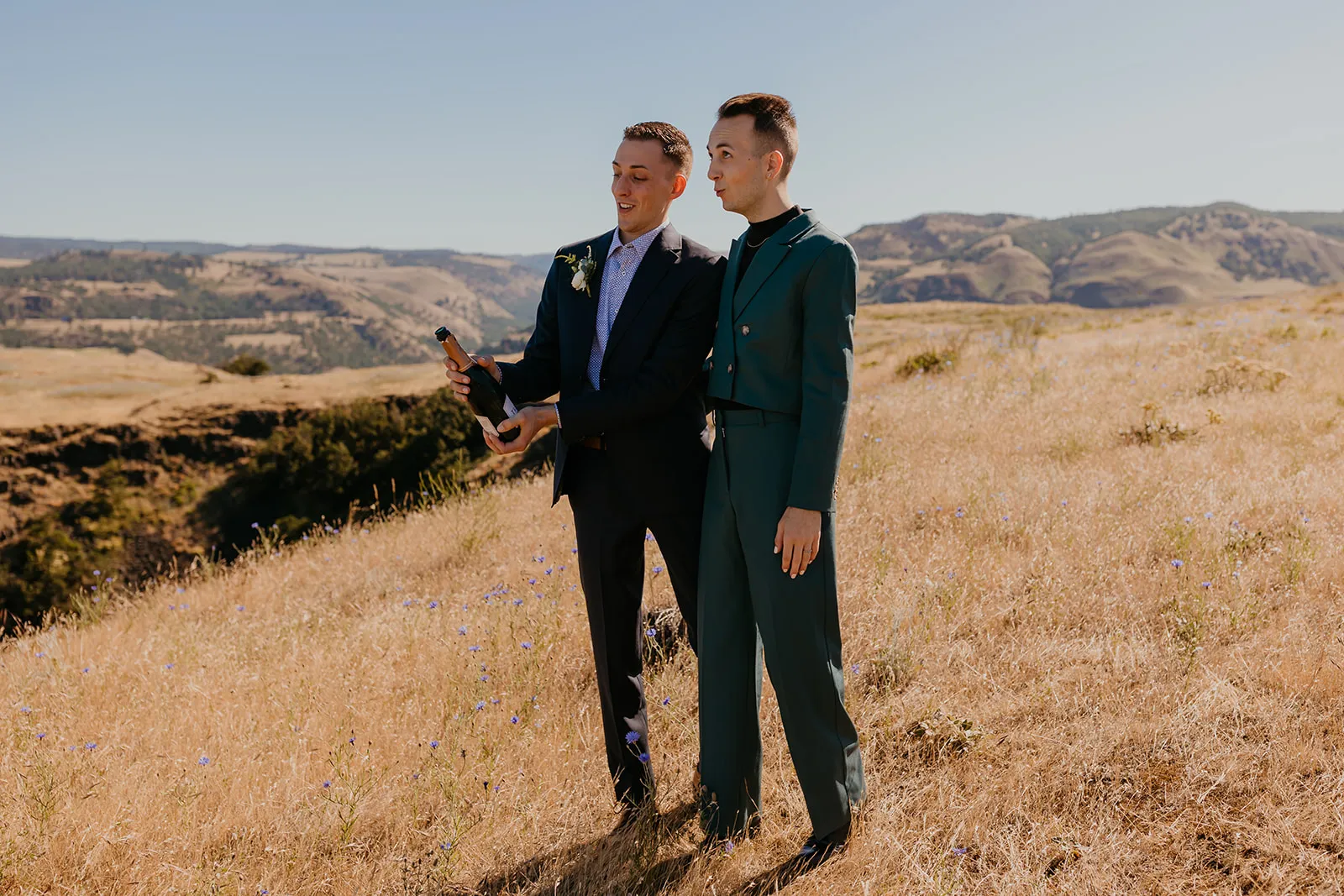 Ben and Nolan open a champagne bottle on a golden hillside at Mayer State Park in Mosier, OR.