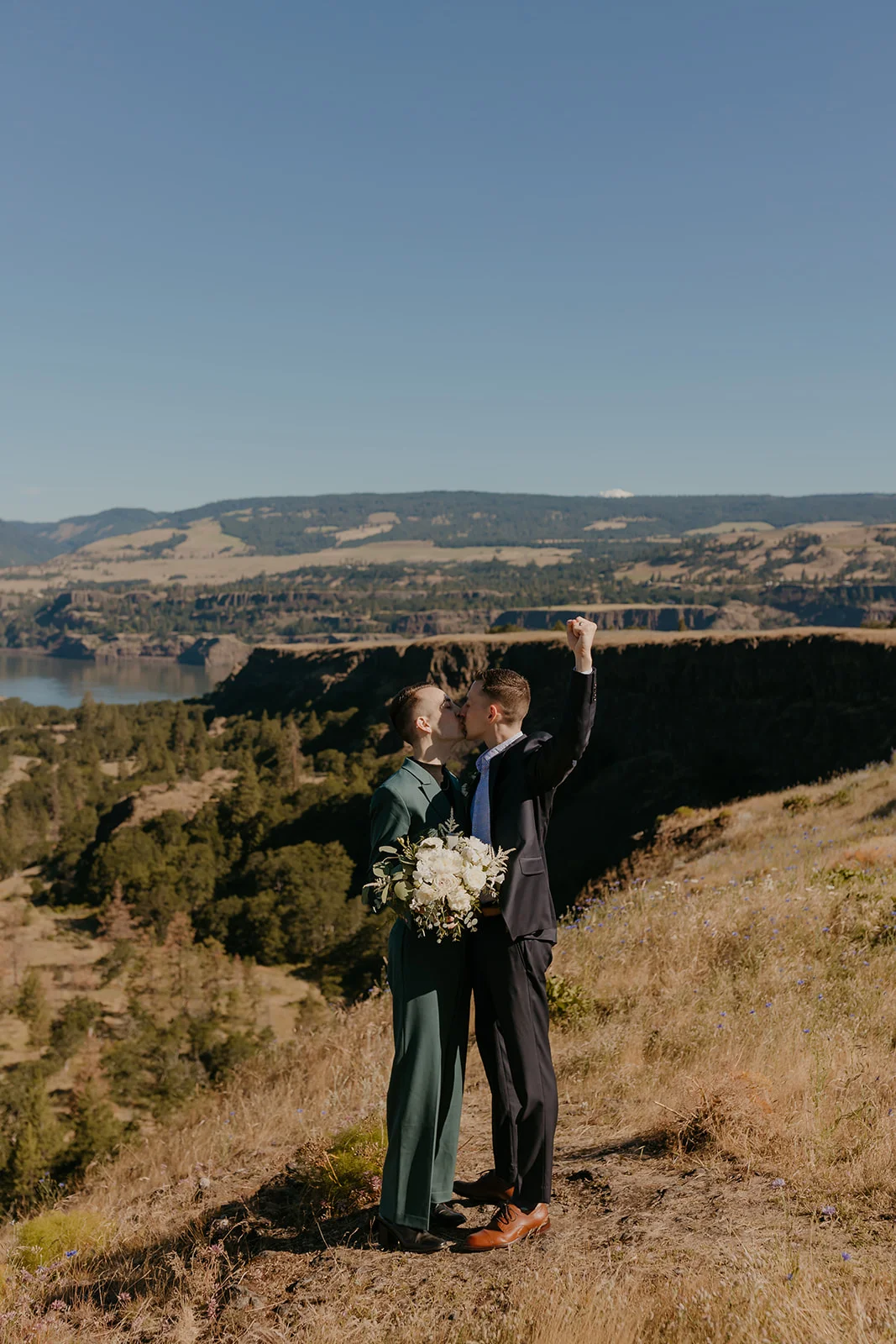 Ben and Nolan share a first kiss with a fist pump at Mayer State Park in Mosier, OR, with the Columbia River Gorge behind them.