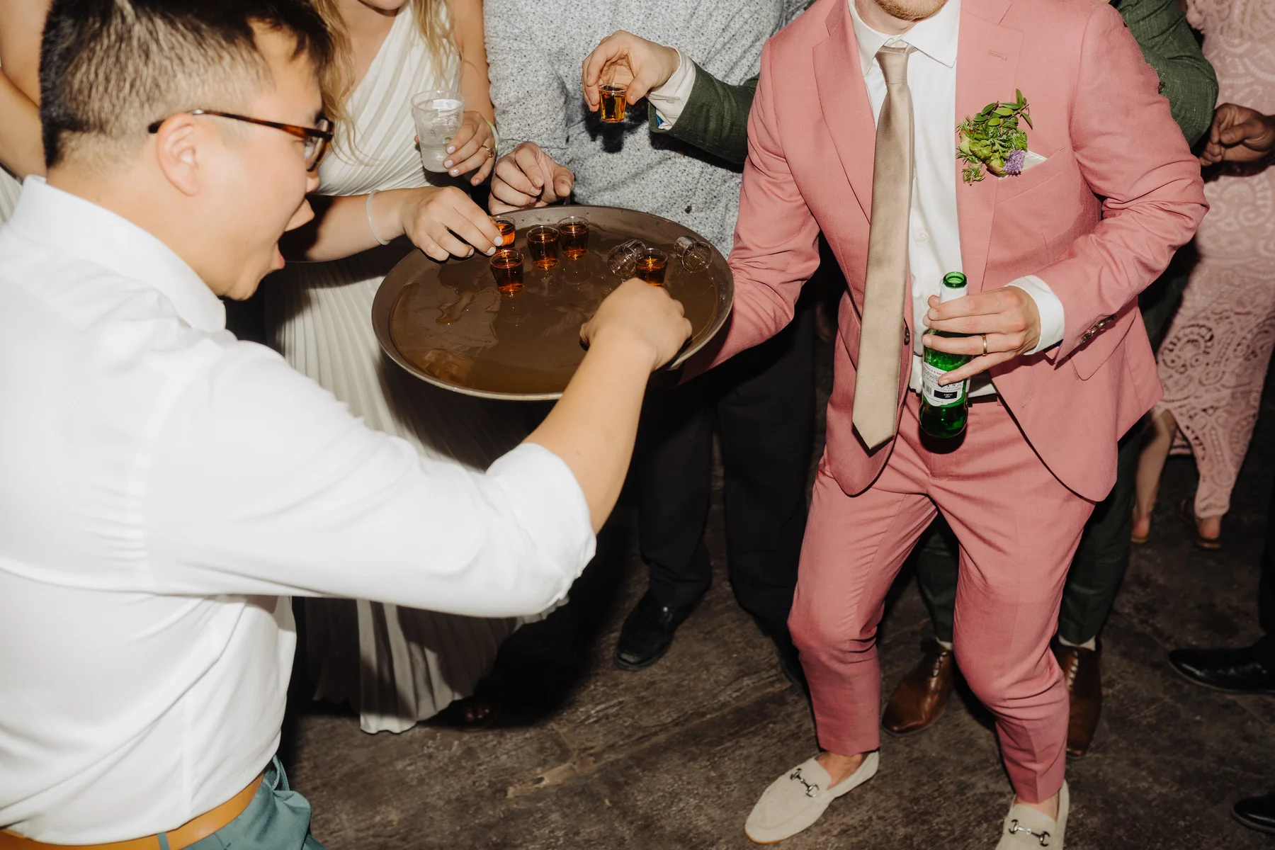 Guests take shots from a tray at Trent and Cameron Harris-McCoy's wedding reception at The Hillside Lodge & Chalets.