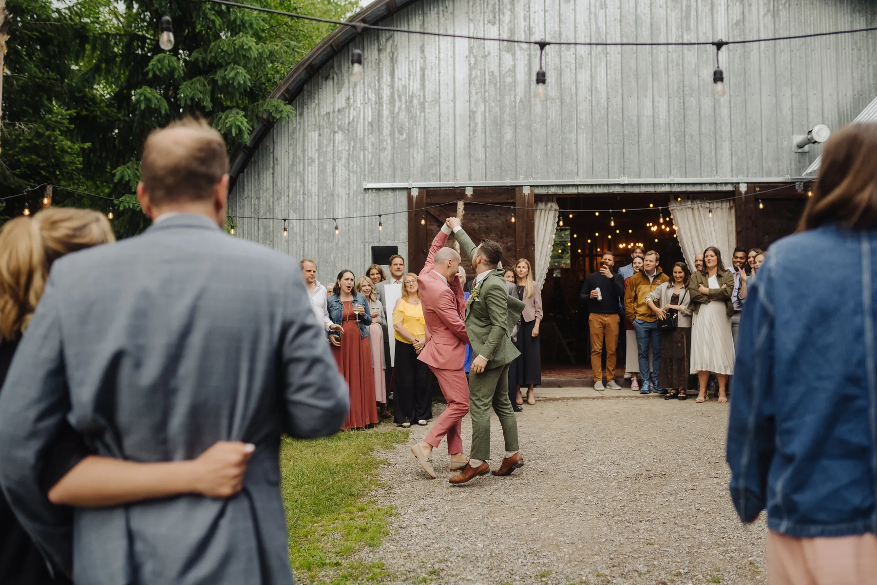 Trent and Cameron Harris-McCoy share their first dance outside The Hillside Lodge in Golden, BC, as guests cheer them on.