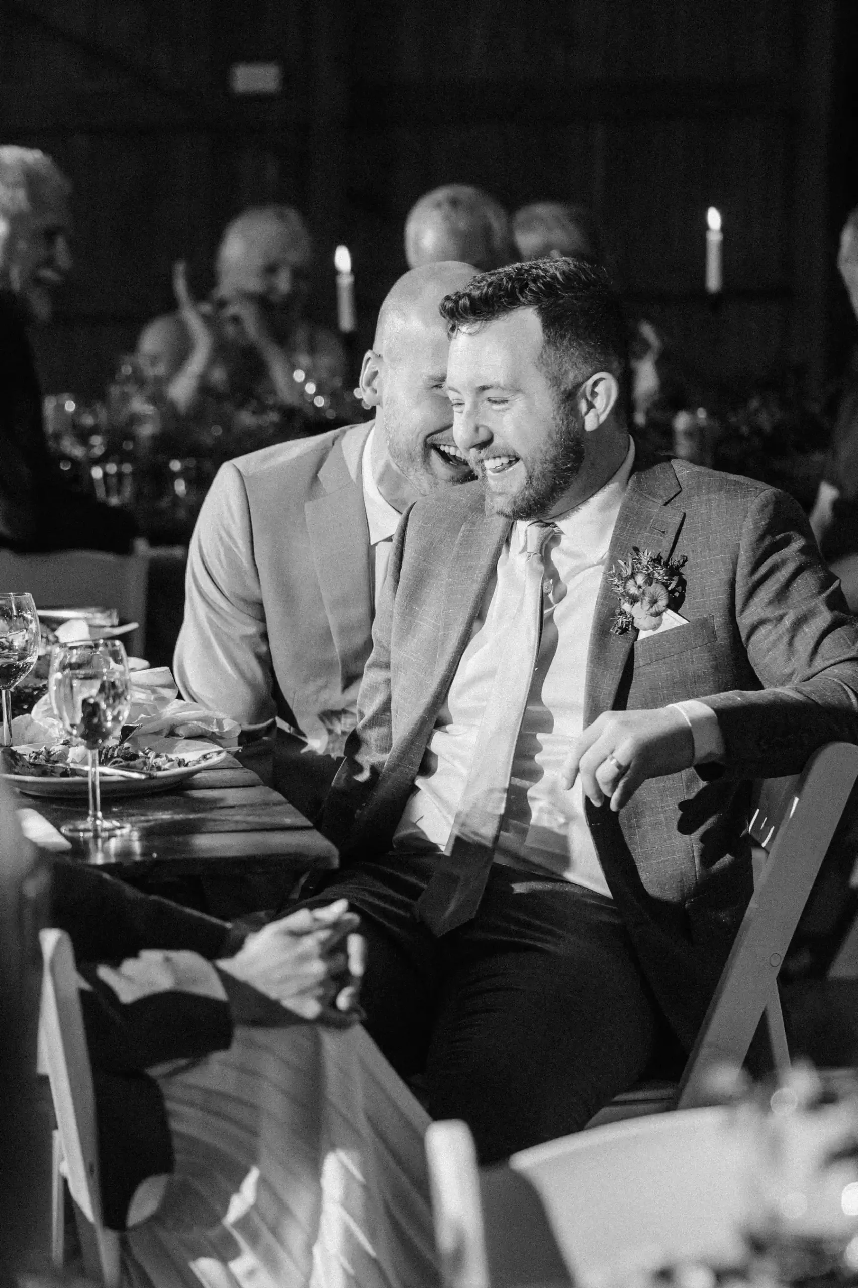 Trent and Cameron Harris-McCoy laugh together at their wedding reception at The Hillside Lodge & Chalets in Golden, BC.