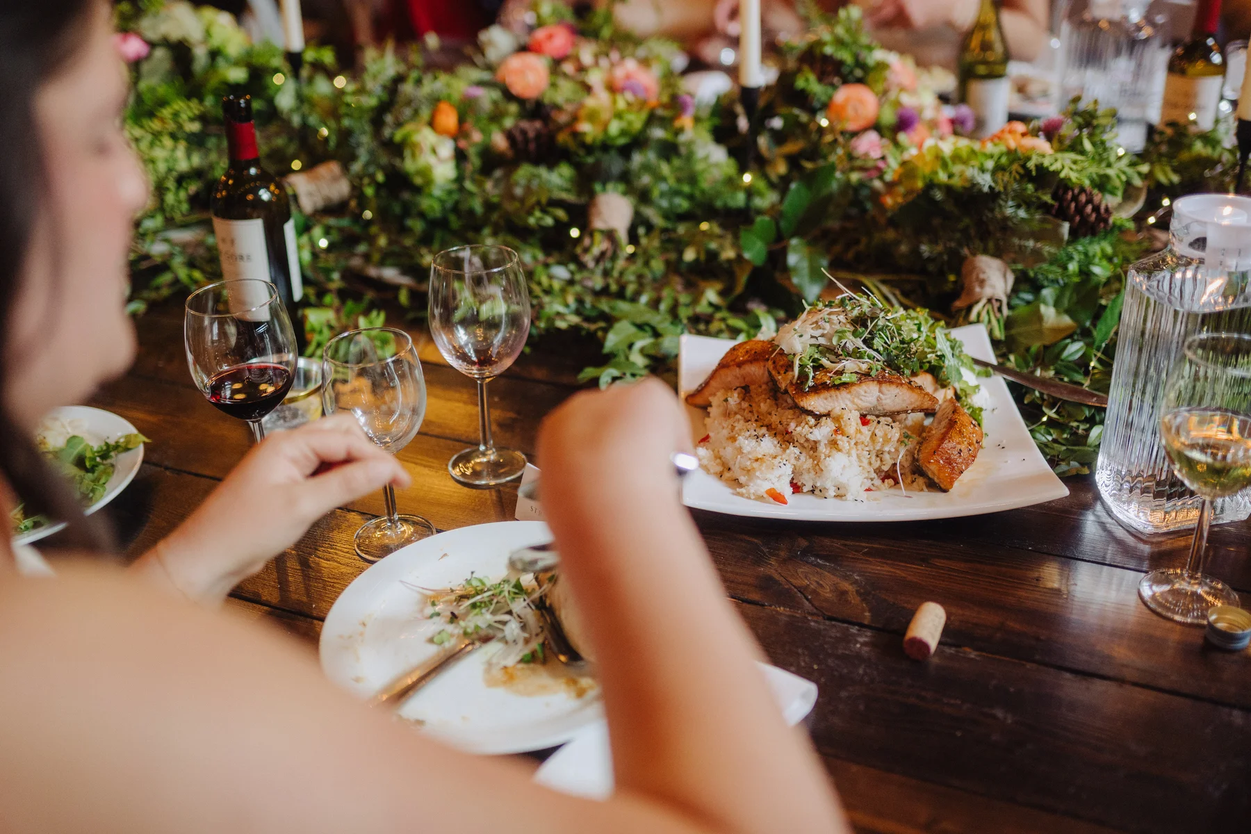 A guest at the wedding reception of Trent and Cameron Harris-McCoy enjoys a plated salmon and rice dinner at The Hillside Lodge, Golden, BC.