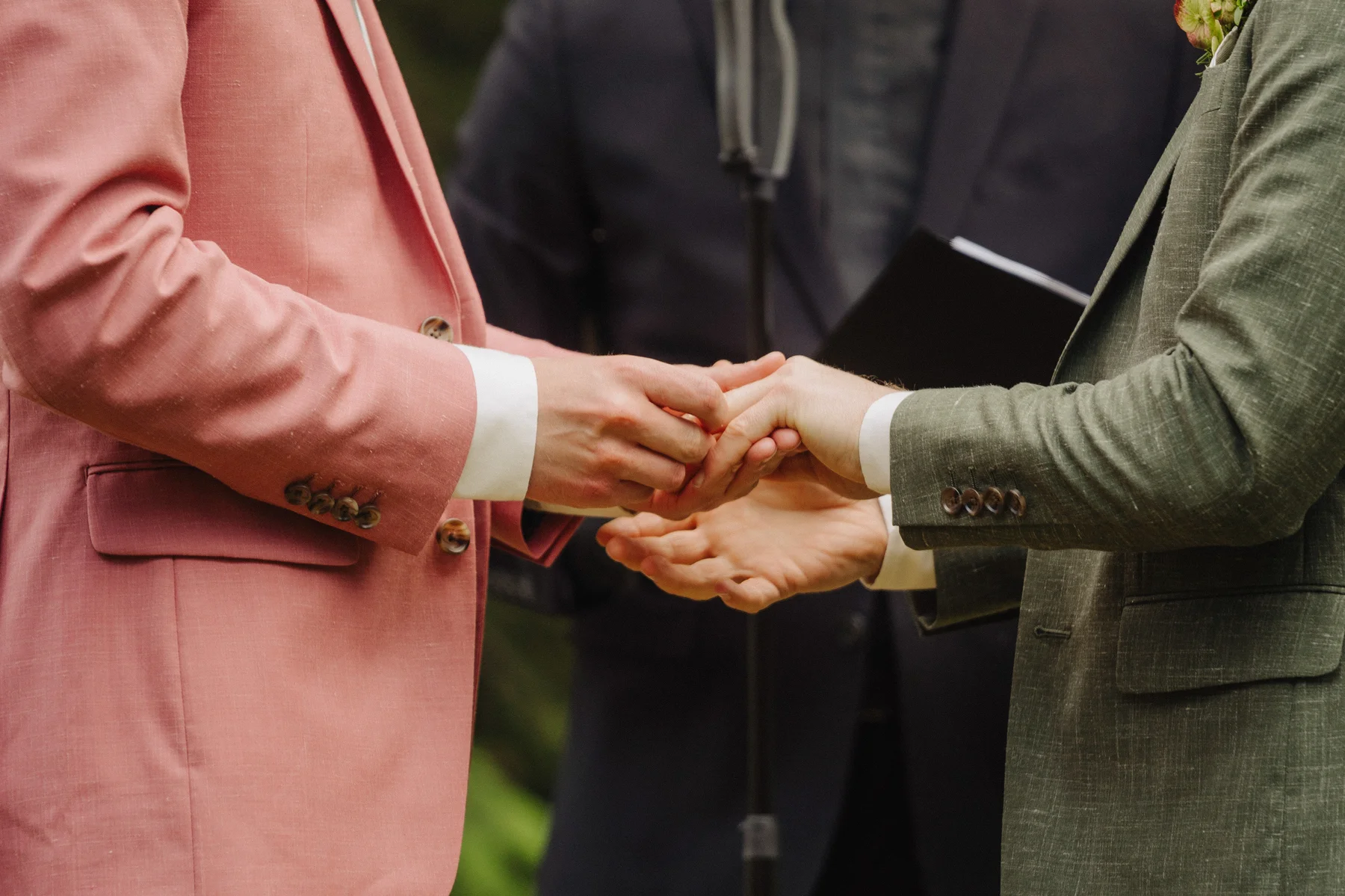 Trent and Cameron Harris-McCoy exchange rings before an officiant at The Hillside Lodge & Chalets in Golden, BC, Canada.