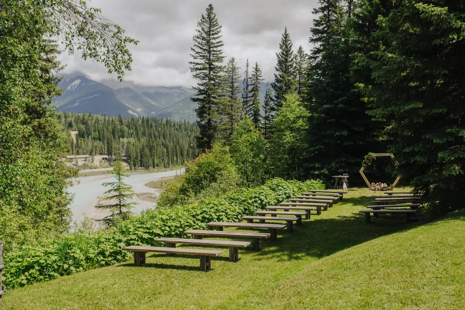 Rows of wooden benches set for an outdoor wedding ceremony at The Hillside Lodge & Chalets in Golden, BC, Canada.