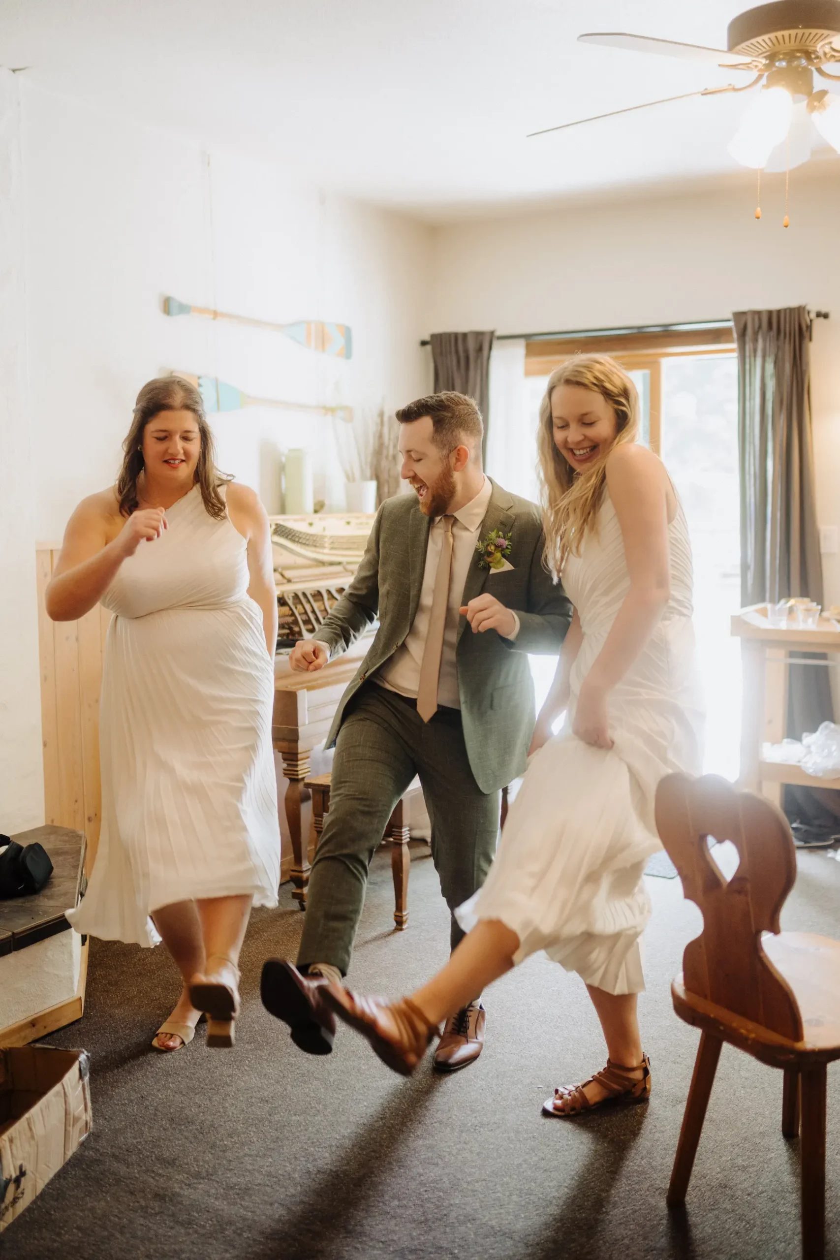 Trent and Cameron Harris-McCoy dance joyfully with a guest inside The Hillside Lodge & Chalets in Golden, BC.