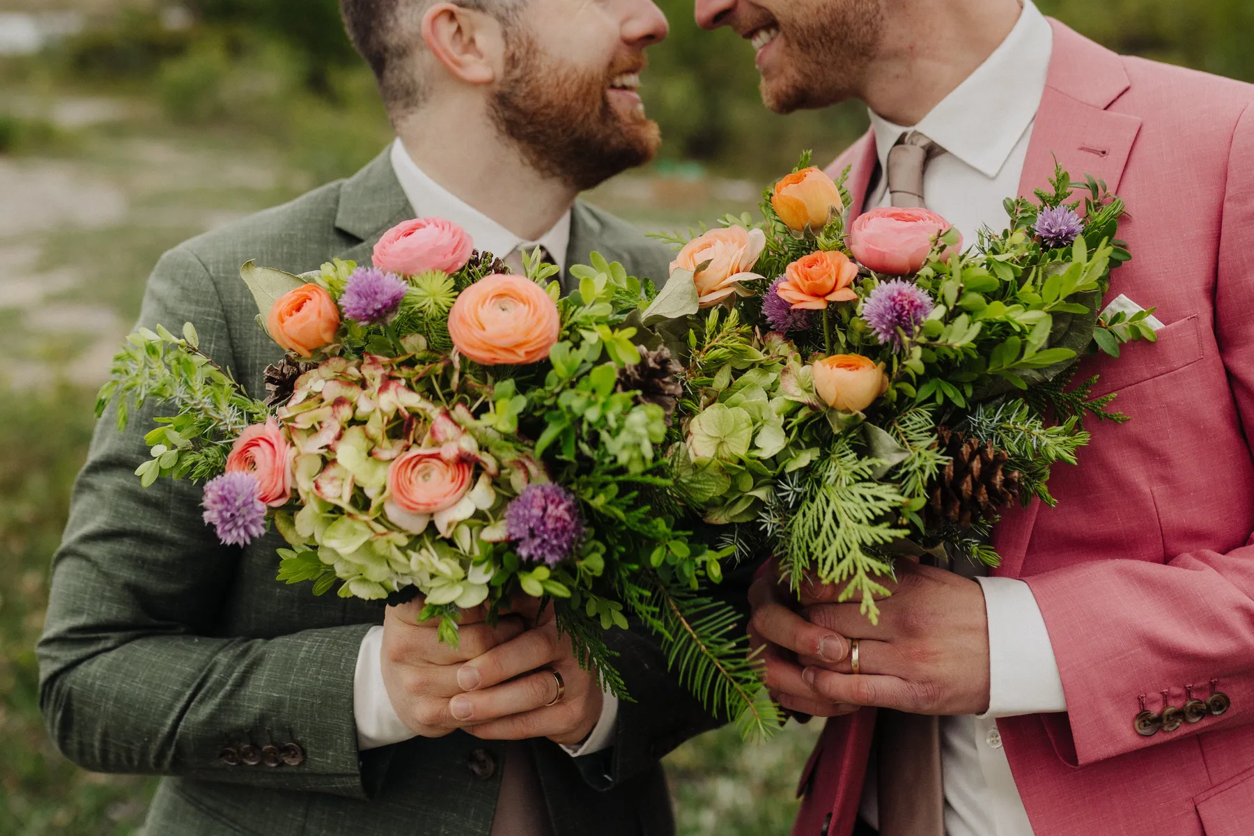 Trent and Cameron Harris-McCoy hold colorful bouquets of ranunculus, roses and greenery at The Hillside Lodge & Chalets.