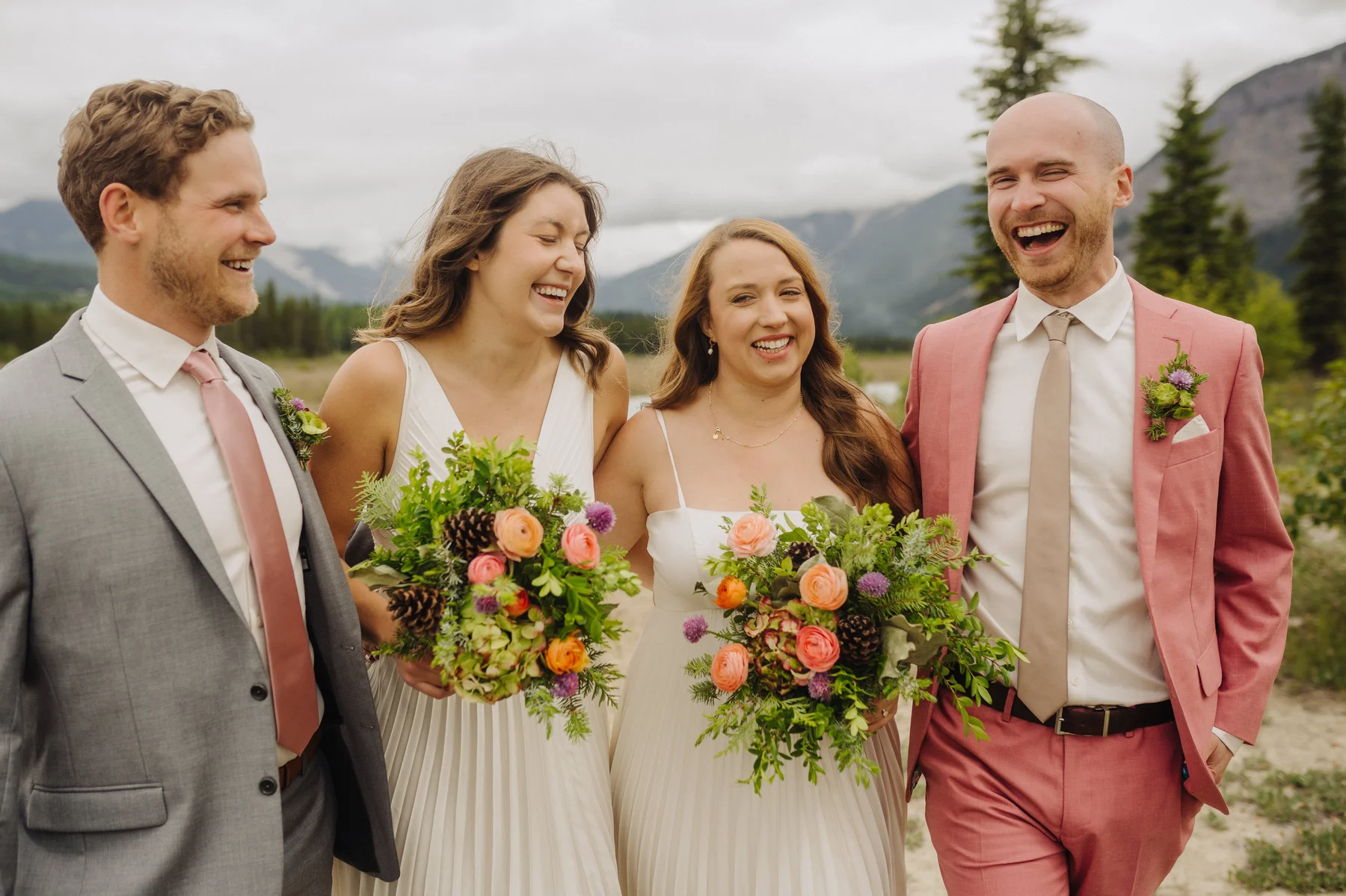 Trent and Cameron Harris-McCoy laugh with their wedding party outdoors at The Hillside Lodge & Chalets in Golden, BC.