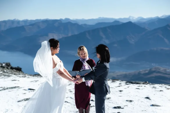 Erika Enerlan and Irish Jacob exchange vows atop The Remarkables in Queenstown, NZ, with snow and mountains behind them.