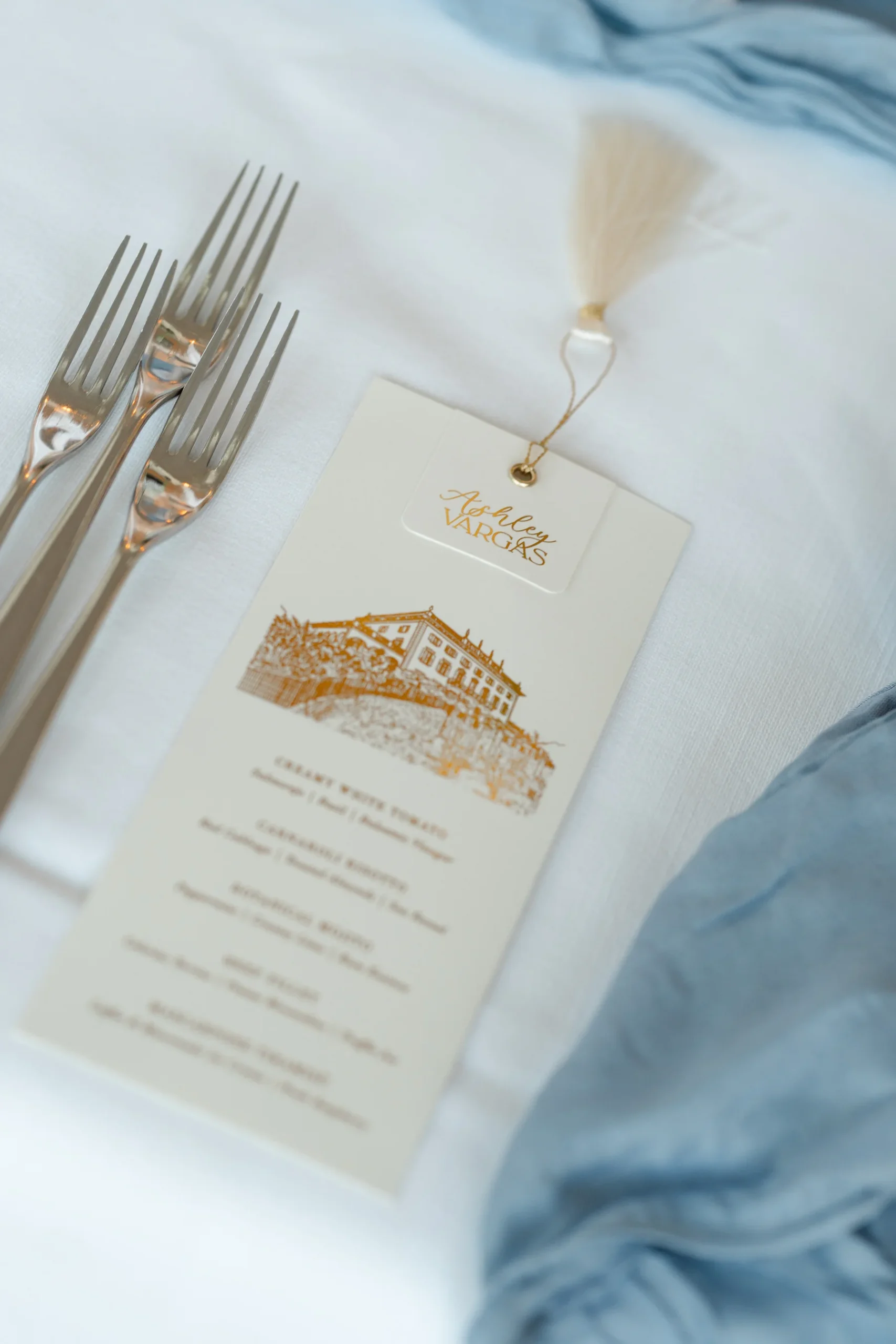 Gold-foil menu card with tassel for Ashley and Dionne Vargas-Rodriguez's wedding at Villa Emden, Brissago Island, Switzerland.