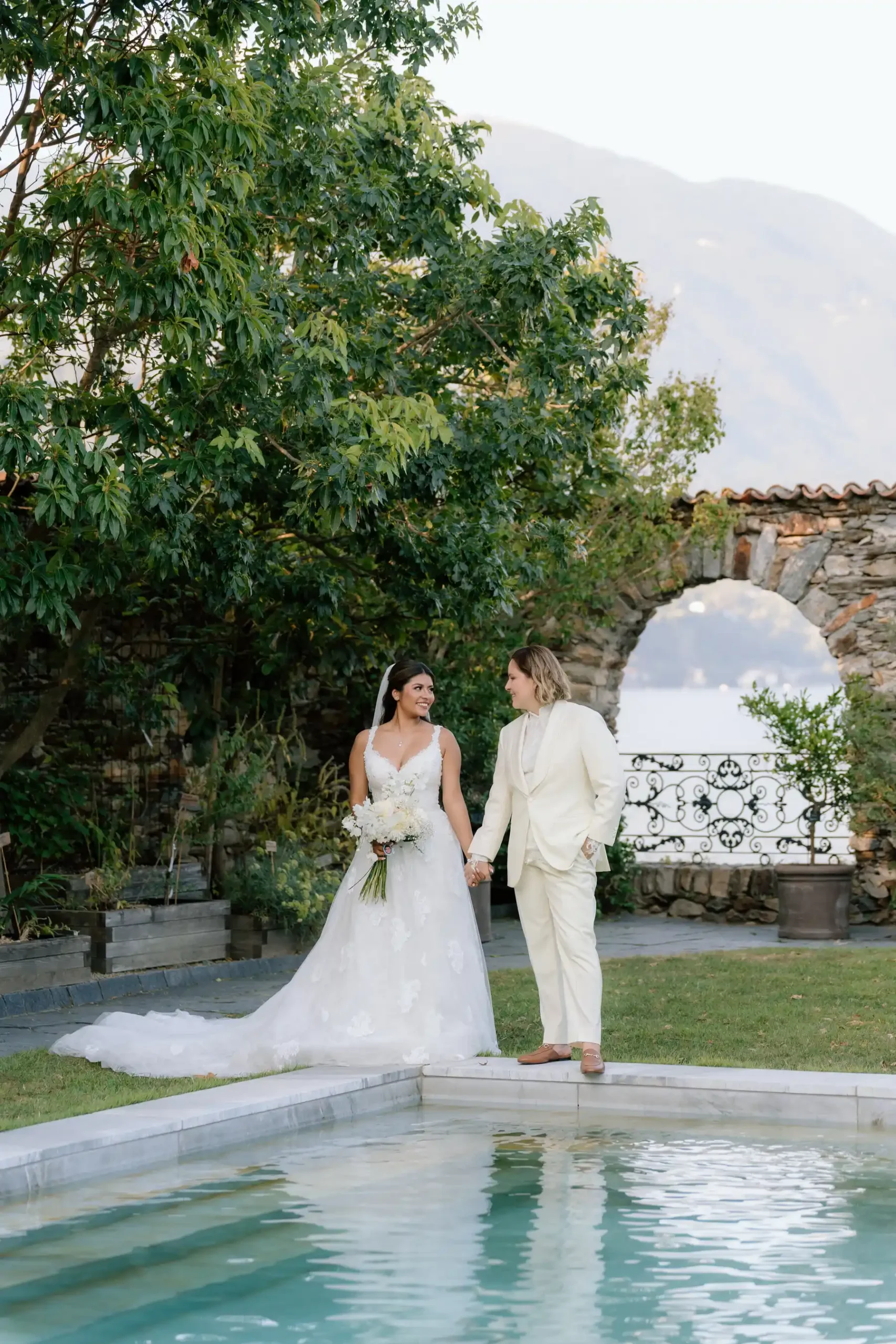 Ashley Rodriguez-Vargas and Dionne Vargas hold hands poolside at Villa Emden on Brissago Island, Switzerland.