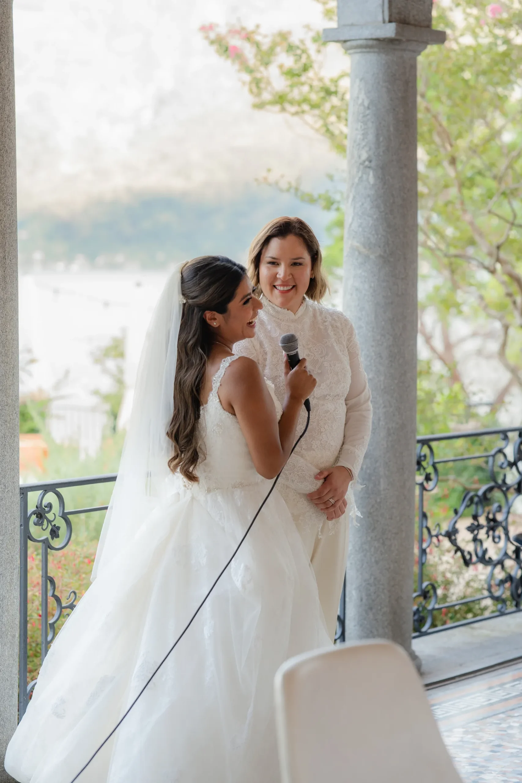 Ashley Rodriguez-Vargas holds a mic during a ceremony moment with Dionne Vargas at Villa Emden, Brissago Island, Switzerland.