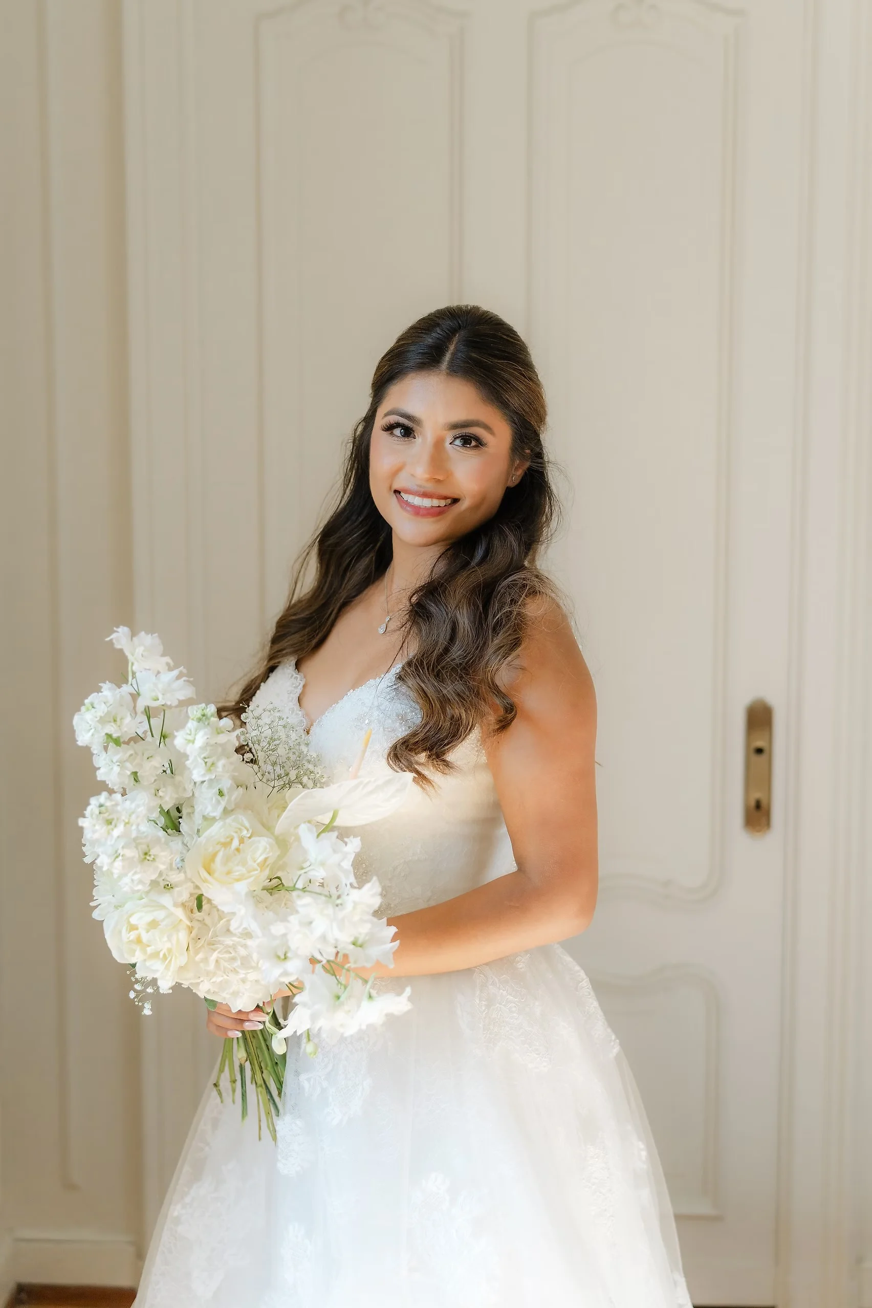 Bride Ashley Rodriguez-Vargas in a white lace gown holds an all-white bouquet at Villa Emden, Brissago Island, Switzerland.
