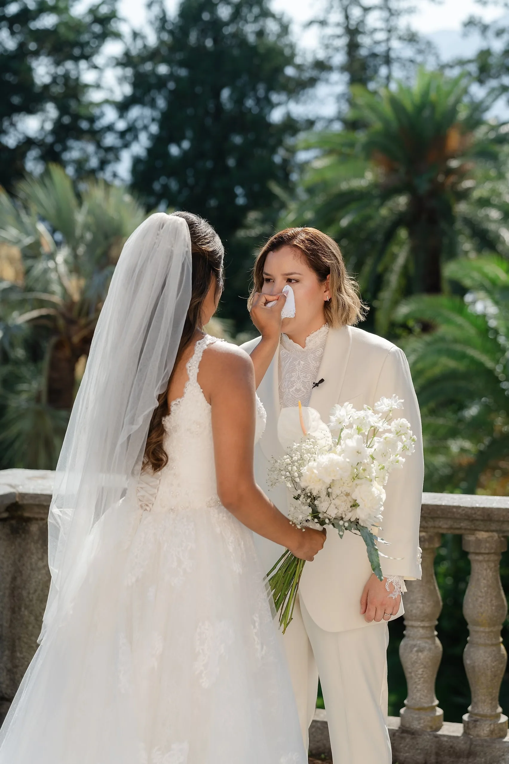 Ashley wipes tears from Dionne's cheek during their wedding at Villa Emden on Brissago Island, Switzerland.