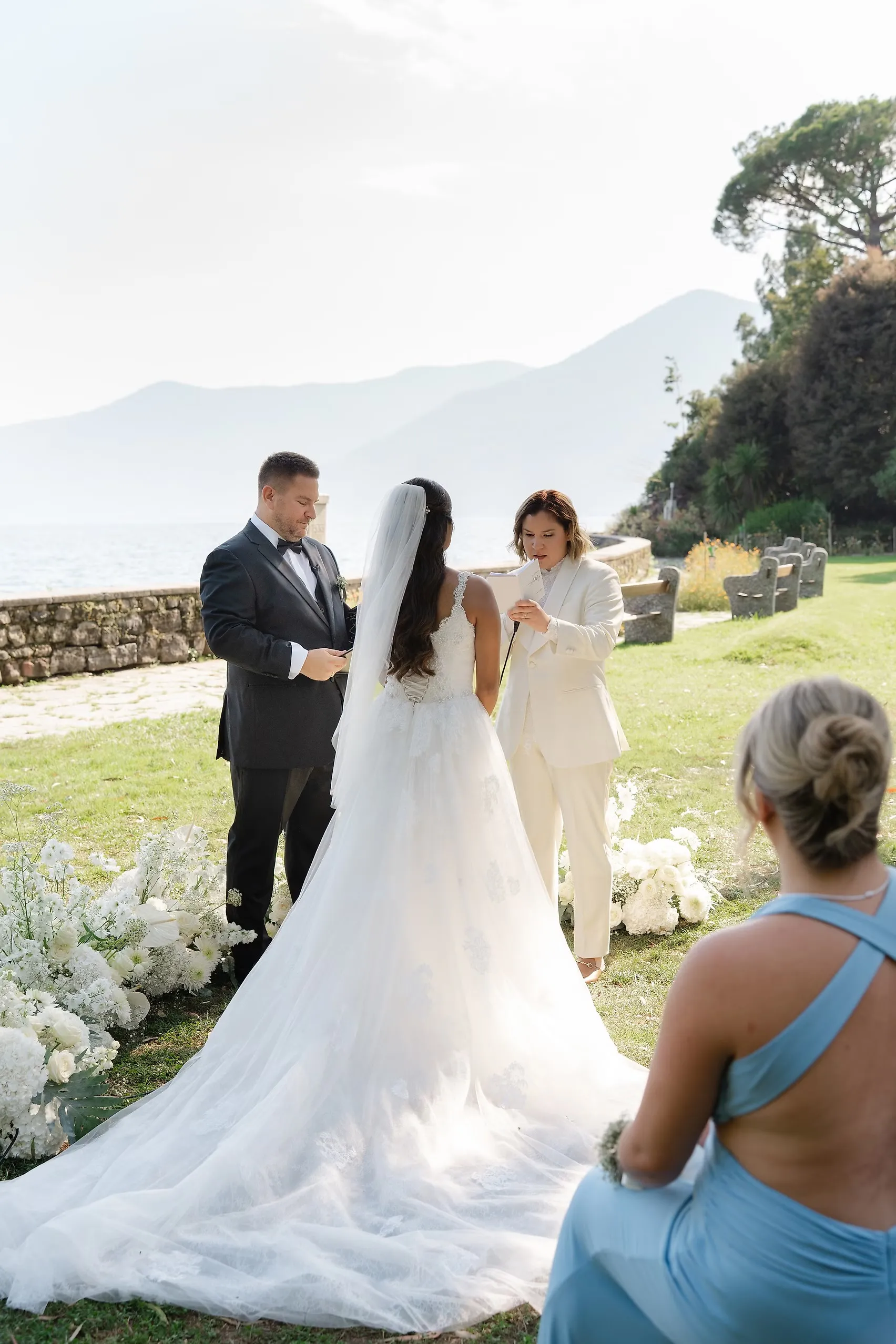 Ashley Rodriguez-Vargas and Dionne Vargas exchange vows at Villa Emden on Brissago Island, Switzerland, surrounded by white florals.