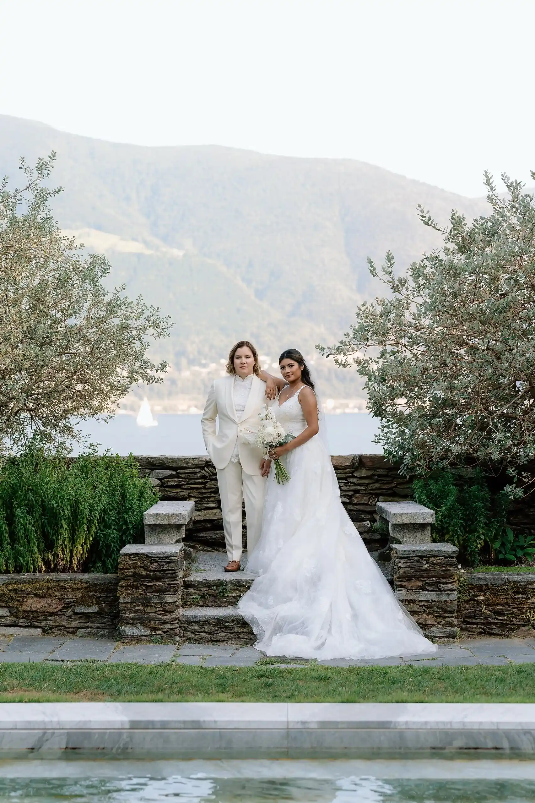 Ashley and Dionne Vargas pose together in wedding attire at Villa Emden on Brissago Island, Switzerland.