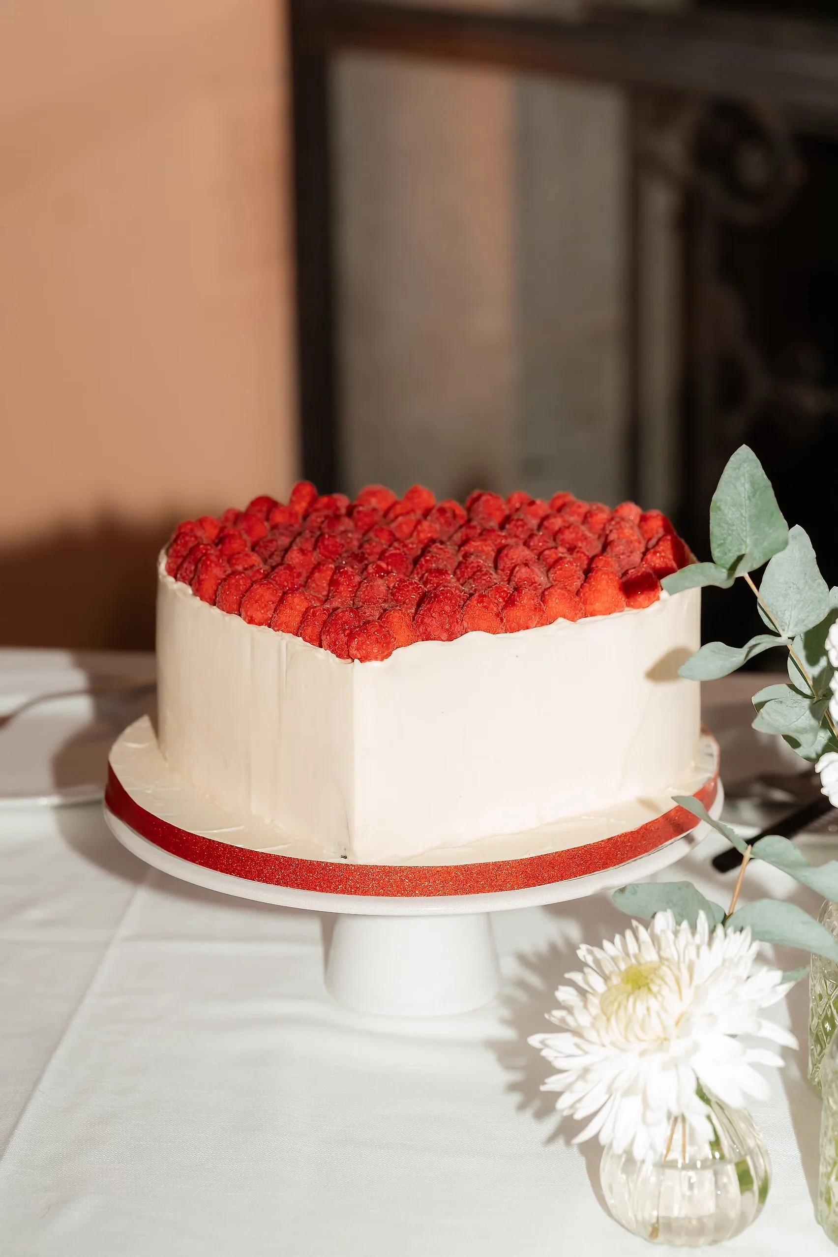 White cream cake topped with fresh strawberries on a pedestal stand at Villa Emden, Brissago Island, Switzerland.