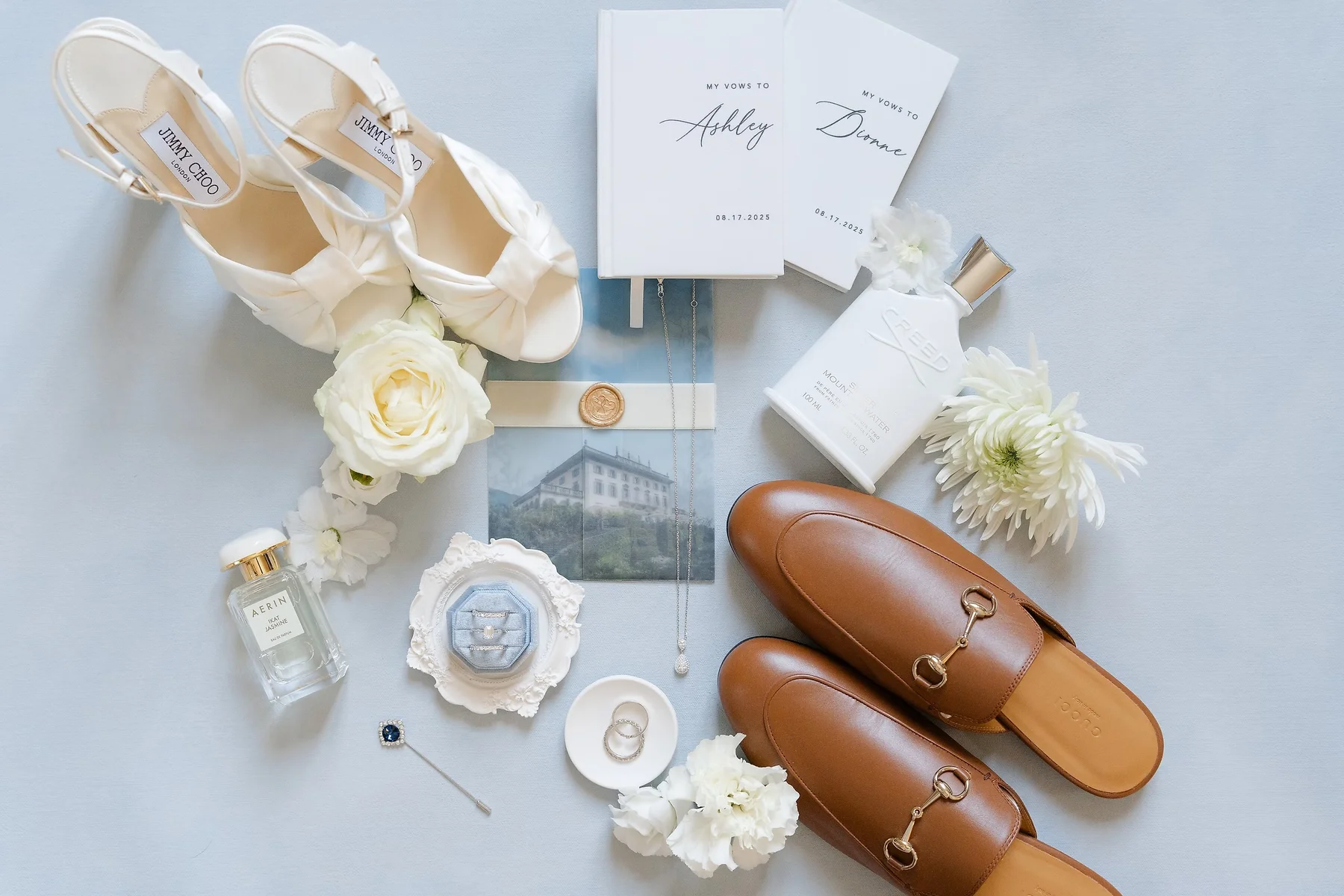 Wedding flat lay with Jimmy Choo heels, Gucci loafers, vow books for Ashley and Dionne, rings, and florals at Villa Emden.