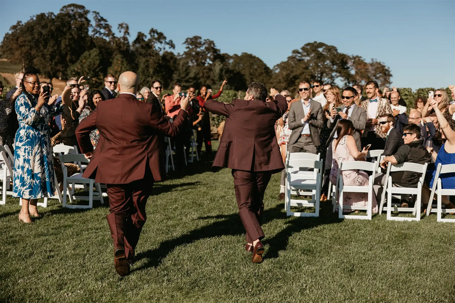Grooms Josue Diaz and Jonathan Snowden dance down the aisle at Stoller Family Estate as guests cheer.
