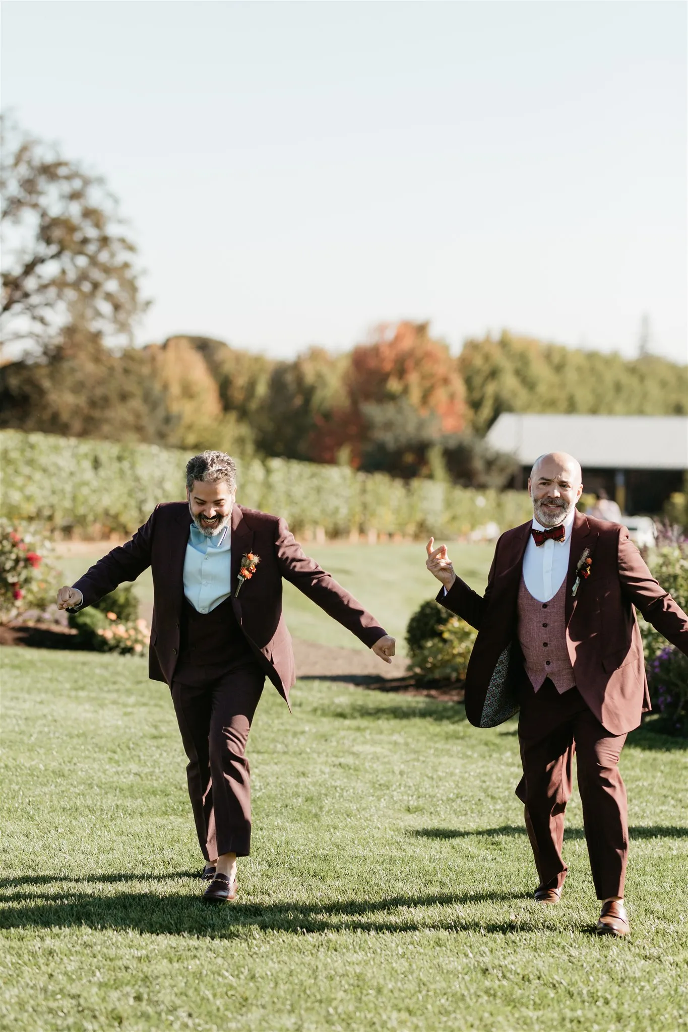 Grooms Josue Diaz and Jonathan Snowden laugh and skip across the lawn at Stoller Family Estate in Dayton, OR.