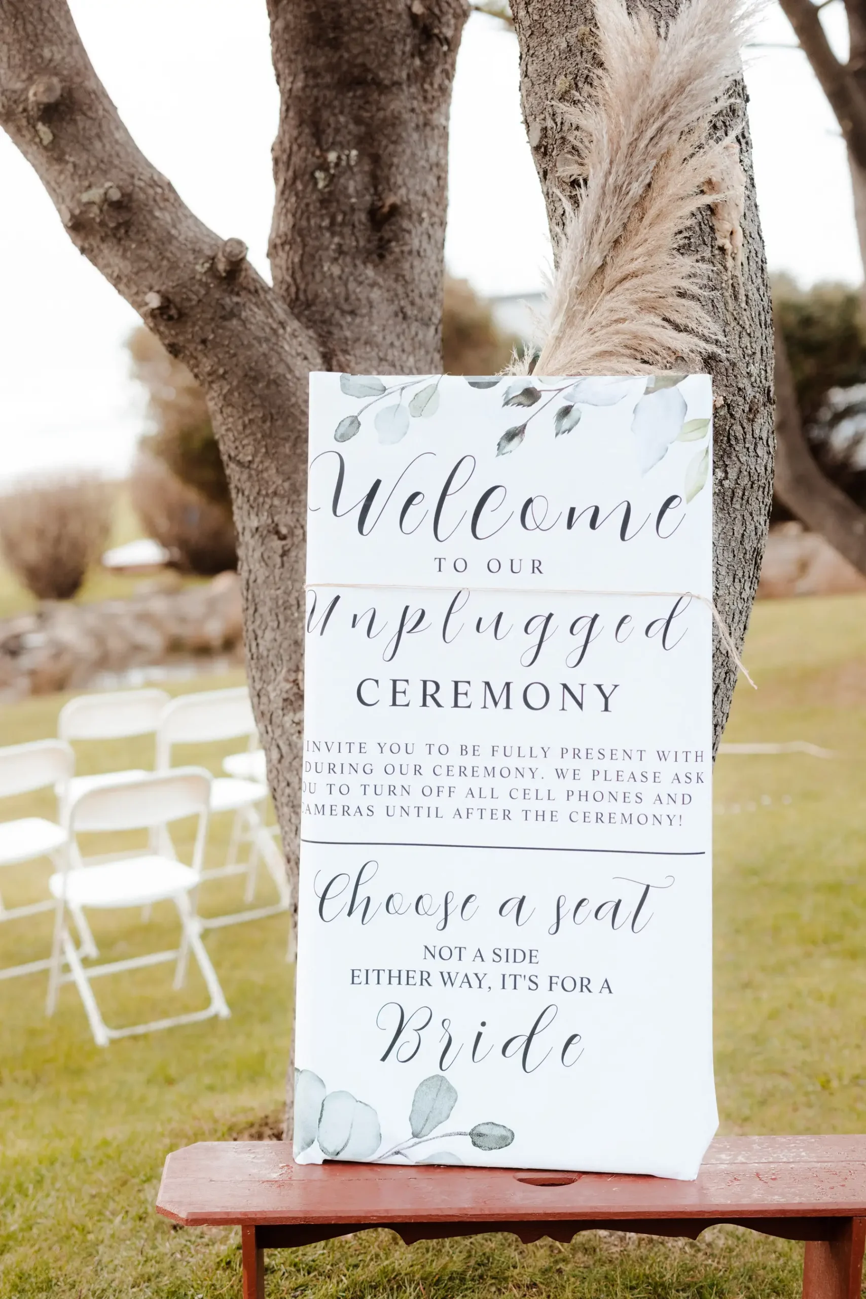 Unplugged ceremony welcome sign leaning against a tree at Yachats Inn in Yachats, Oregon.