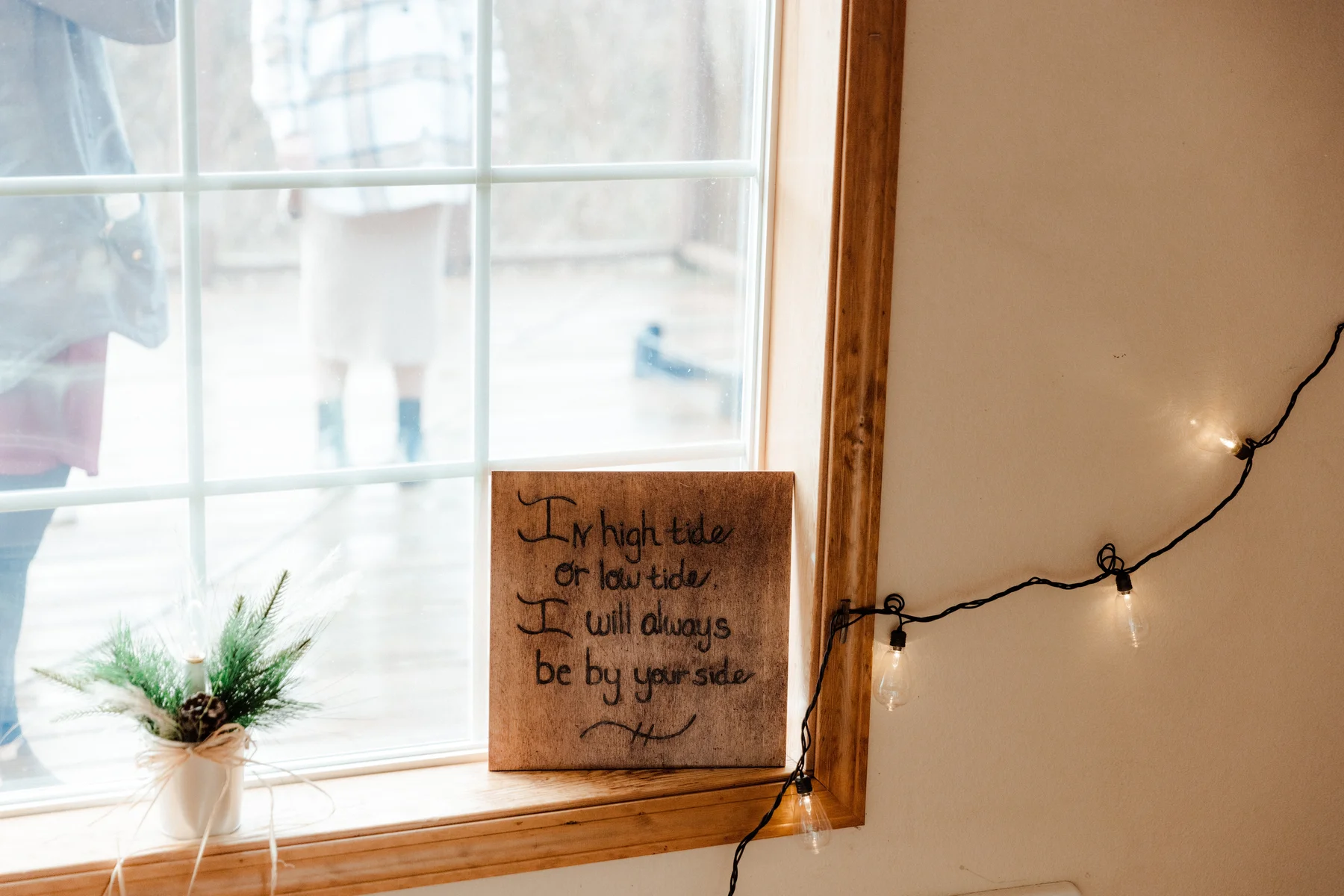 Wooden sign reading 'In high tide or low tide, I will always be by your side' on a window sill at Yachats Inn.