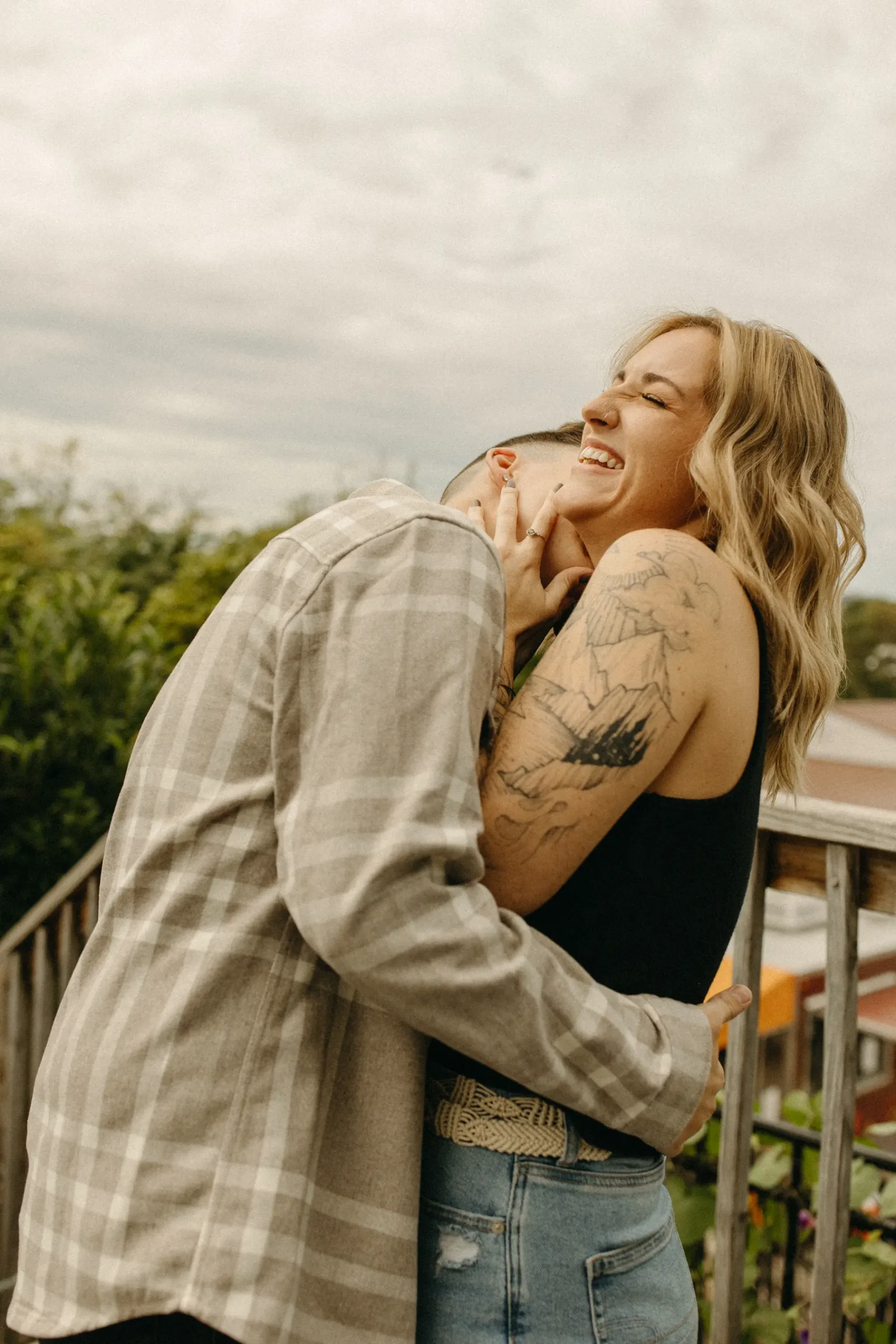 The couple embraces and laughs together on a deck at Gravely Brewing Co in Denver, Colorado.