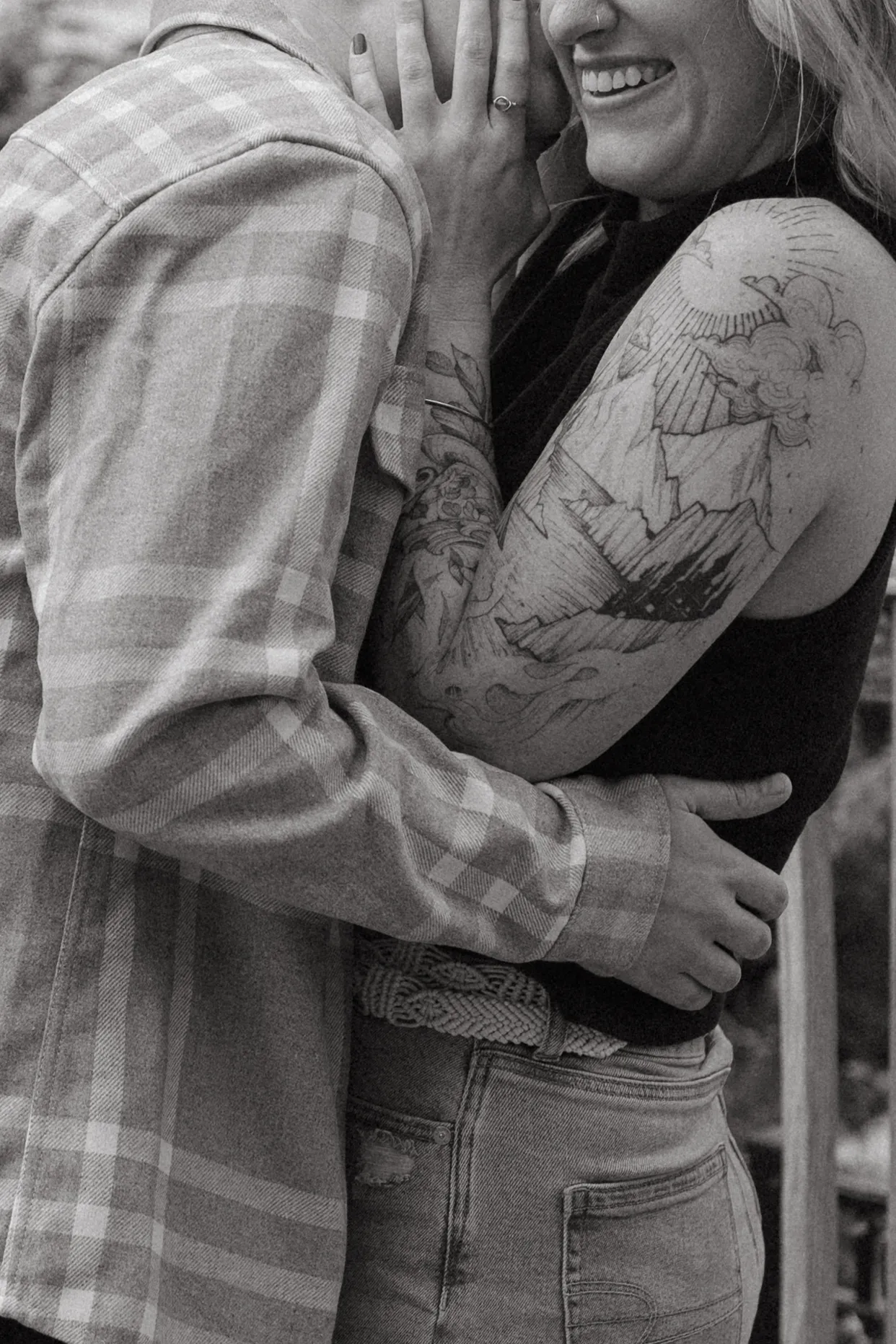 The couple embraces and laughs at Gravely Brewing Co in Denver, Colorado, showcasing an intricate mountain-scene tattoo sleeve.