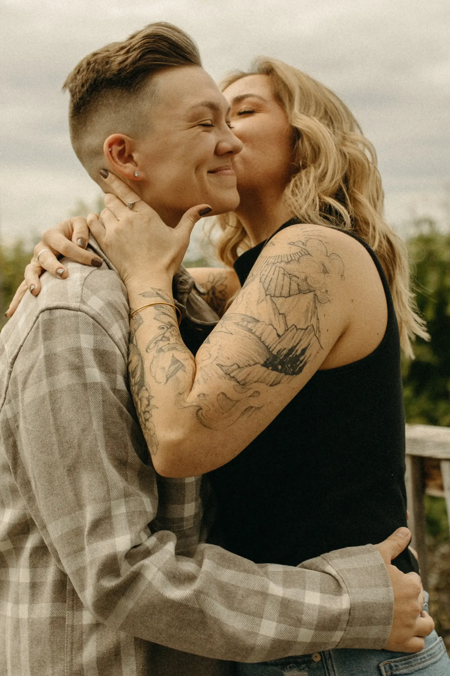 The couple embraces and shares a tender kiss during their engagement session at Gravely Brewing Co in Denver, Colorado.