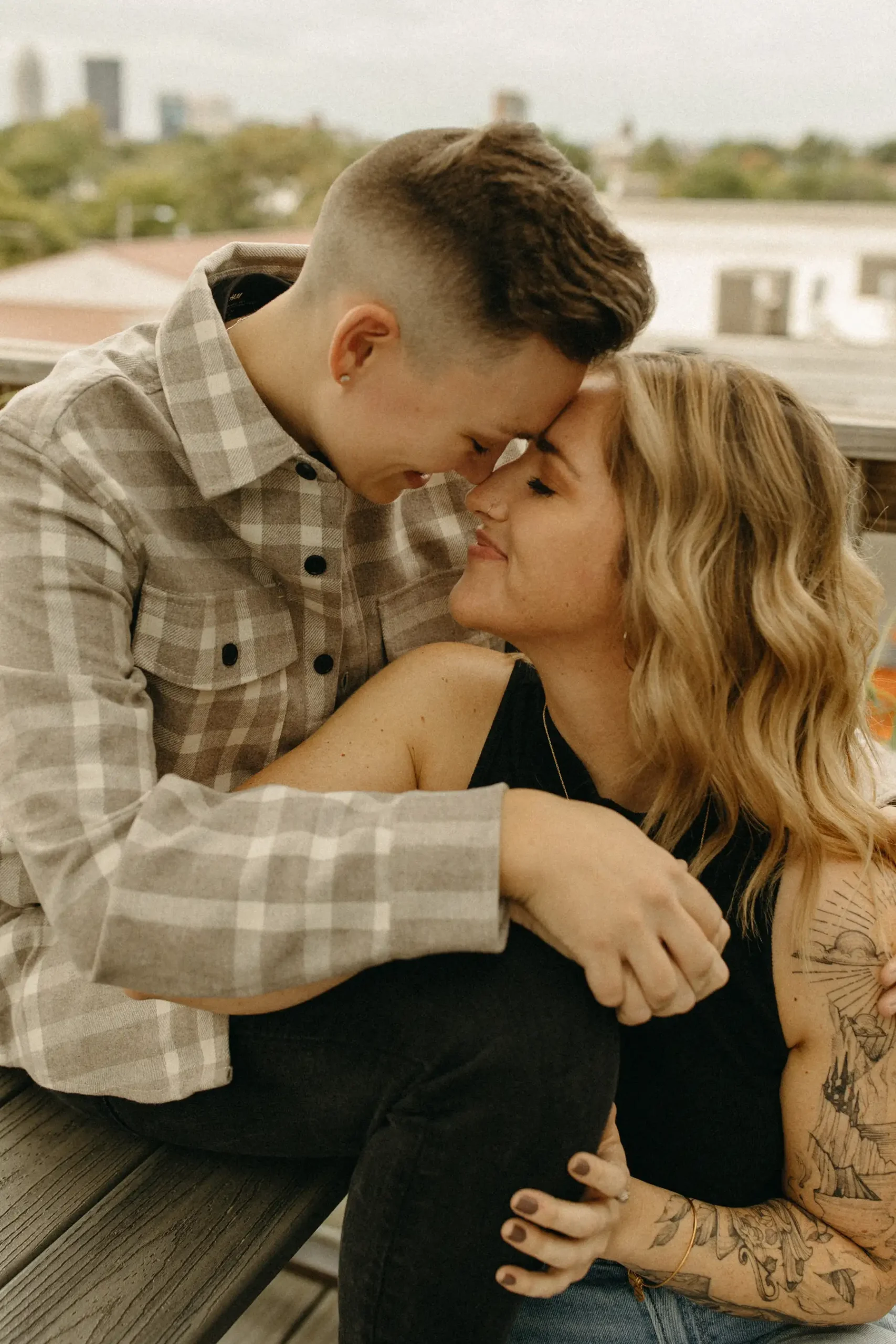 The couple leans foreheads together, nearly kissing, during their engagement session at Gravely Brewing Co in Denver, Colorado.