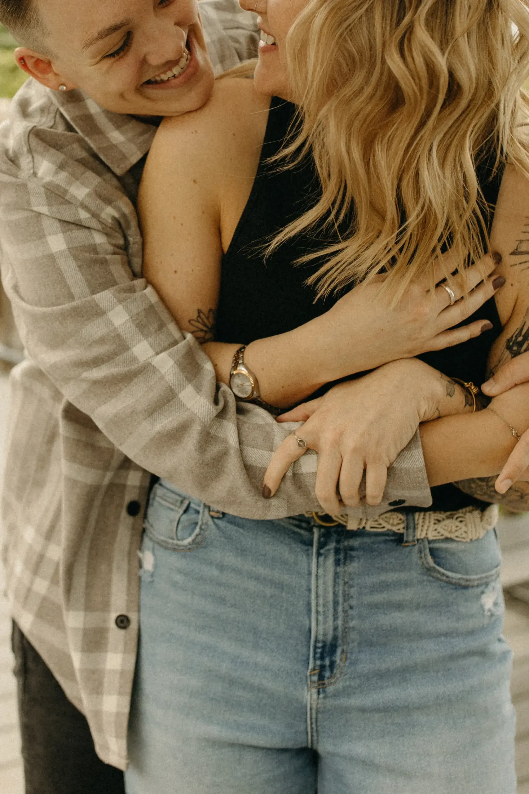 The couple embraces and laughs together during their engagement session at Gravely Brewing Co in Denver, Colorado.