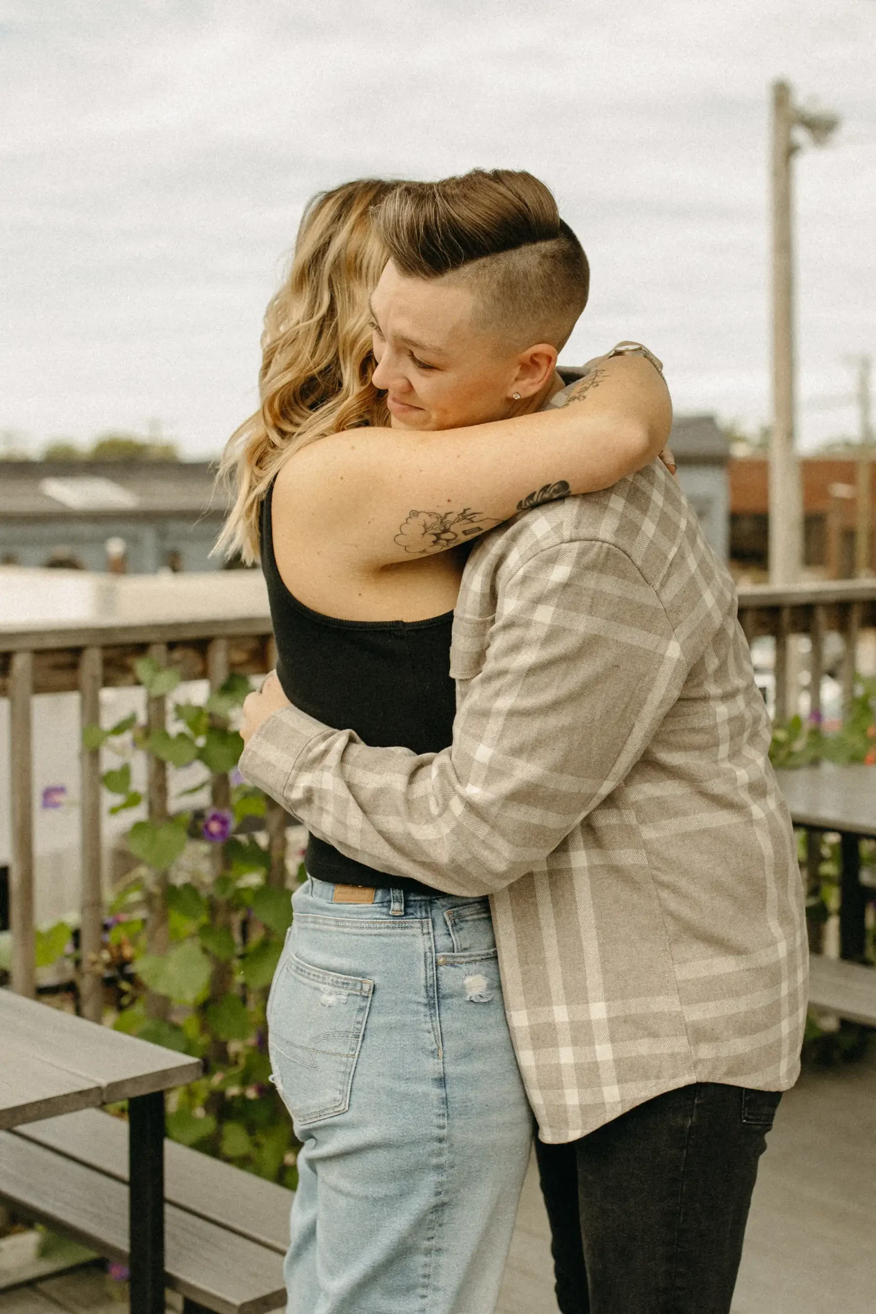 The couple shares a warm embrace on the outdoor patio at Gravely Brewing Co in Denver, Colorado.
