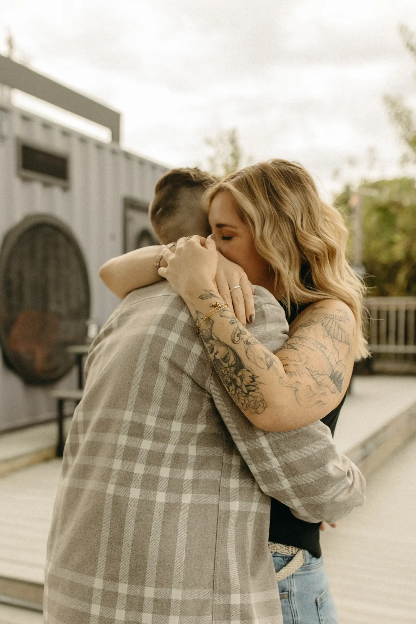 The couple shares a close embrace during their engagement session at Gravely Brewing Co in Denver, Colorado.