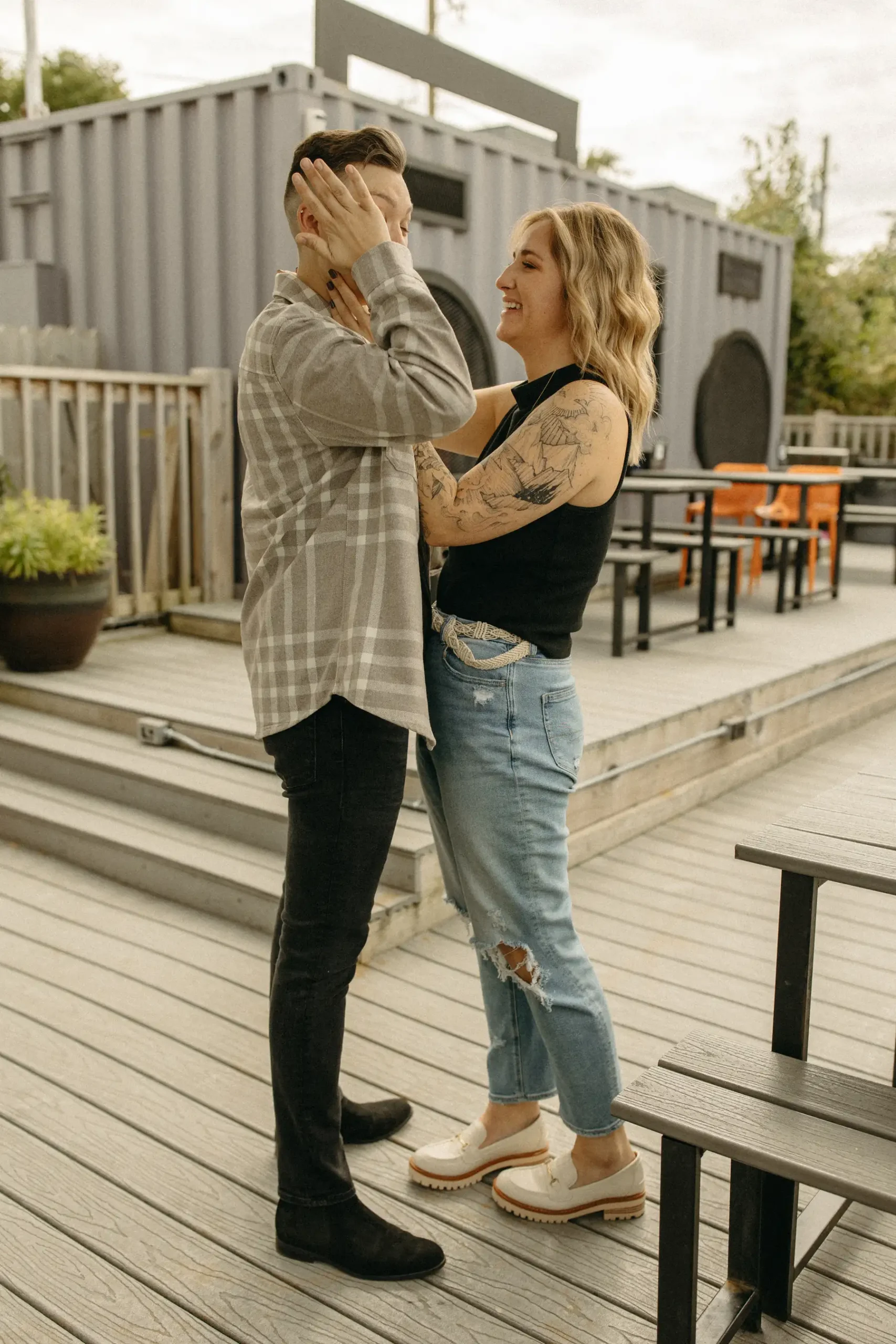 A couple laughs and embraces on the outdoor deck at Gravely Brewing Co in Denver, Colorado.
