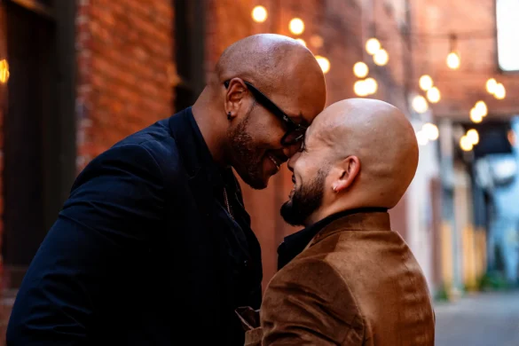 The couple leans in close, foreheads nearly touching, sharing a tender moment in a warmly lit alley in Goldsboro, NC.