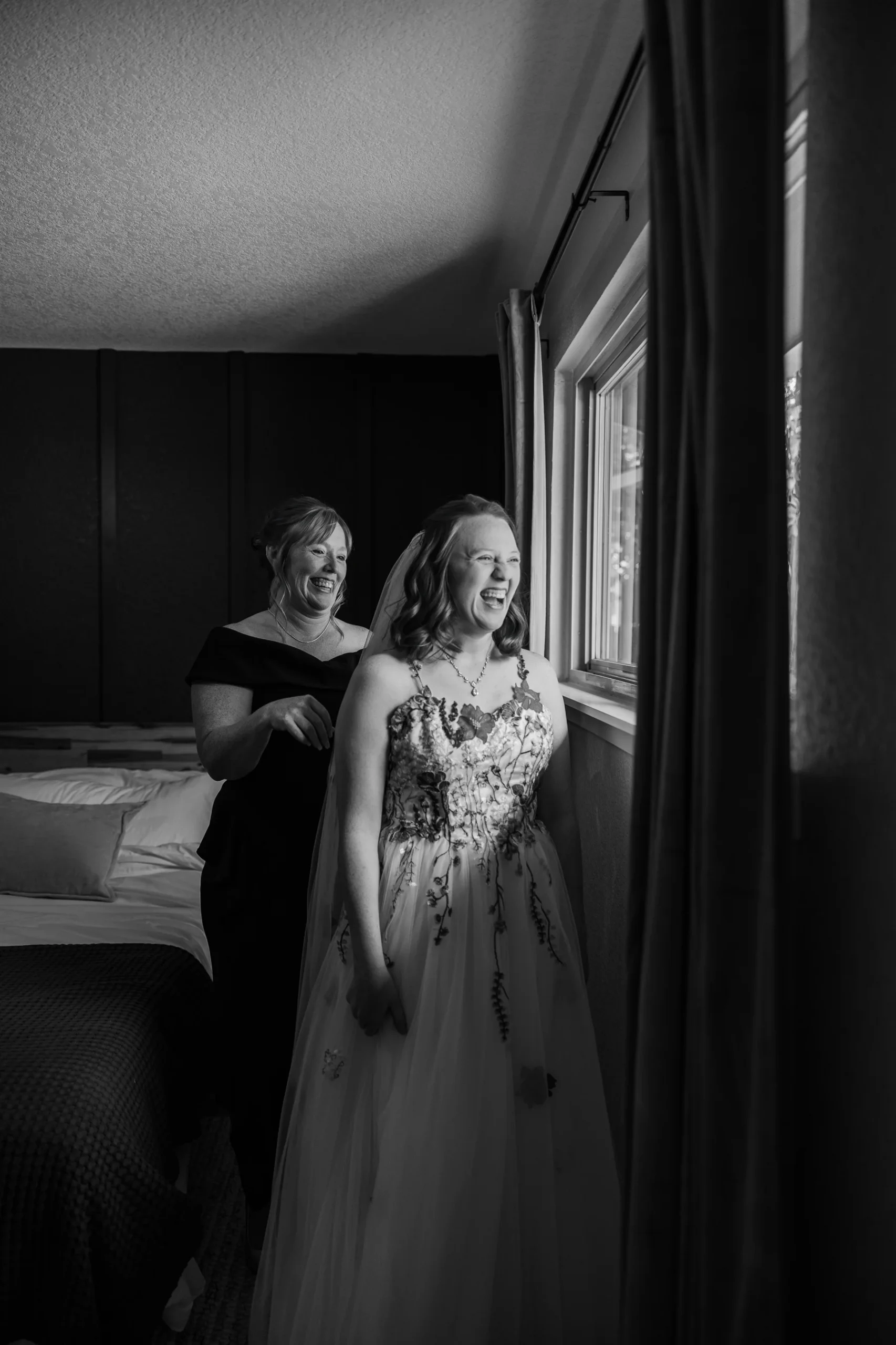 Hannah Rusow laughs as someone helps her with her veil in a bedroom at Halfway House in Boulder, CO.